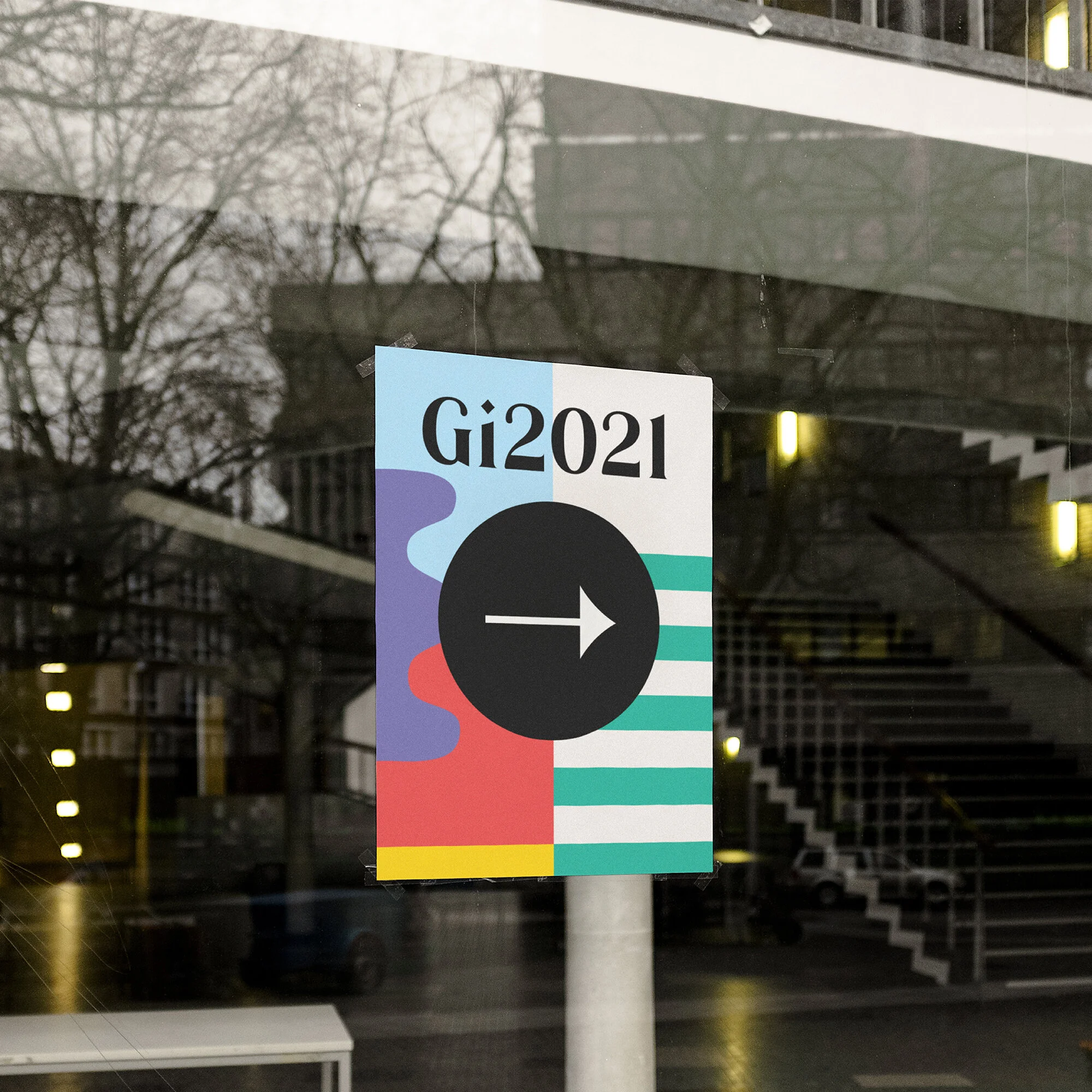 A colorful directional sign for the GID 2021 event, featuring a black circle with a white arrow pointing right, and a background with abstract shapes and stripes.