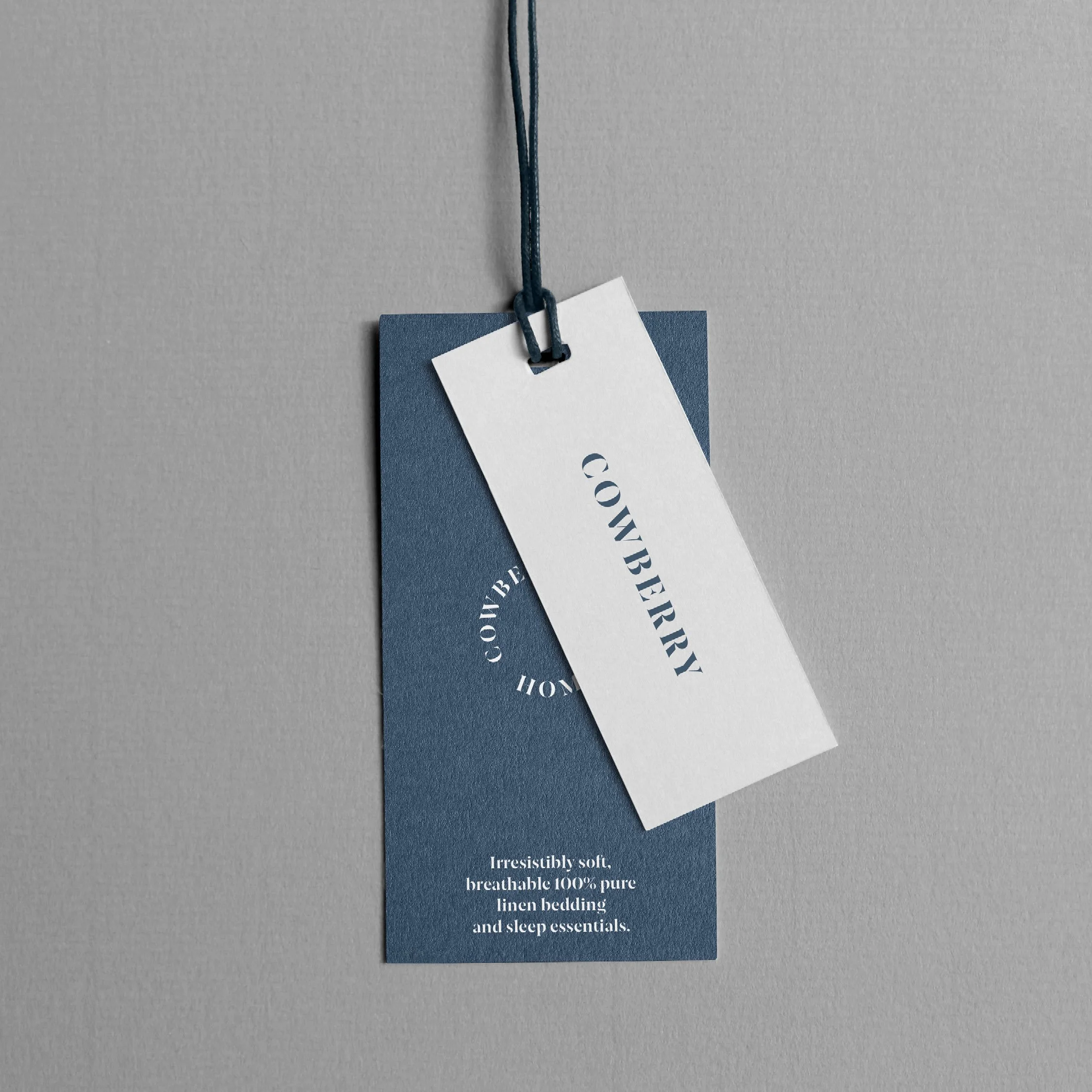 Close-up of blue and white bedding tags hanging from a gray surface, with the word 'COVERS' visible on the tags.