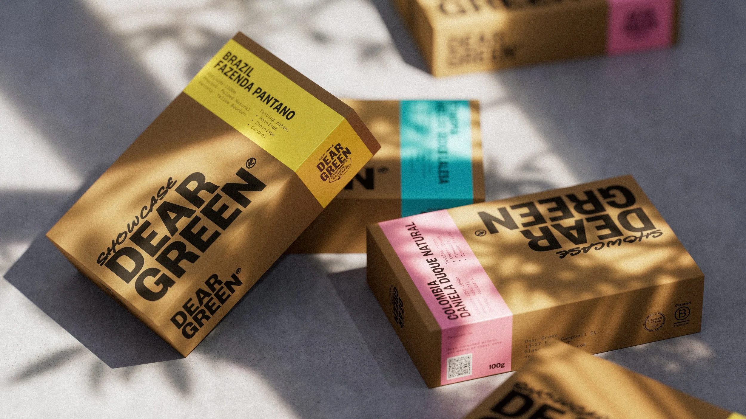 Several chocolate bar packaging with colorful labels, including yellow, pink, and blue, lying on a surface with shadows.