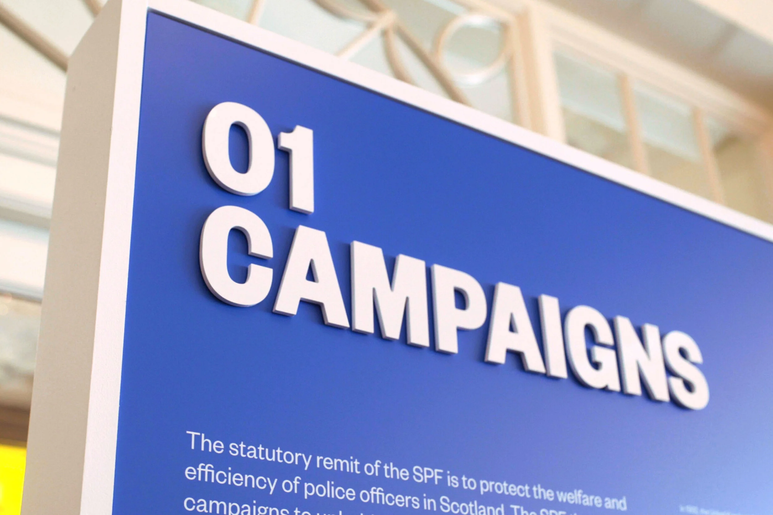 Sign with the text '01 CAMPAIGNS' and a paragraph about the statutory remit of the SPF and its support for police officers in Scotland.