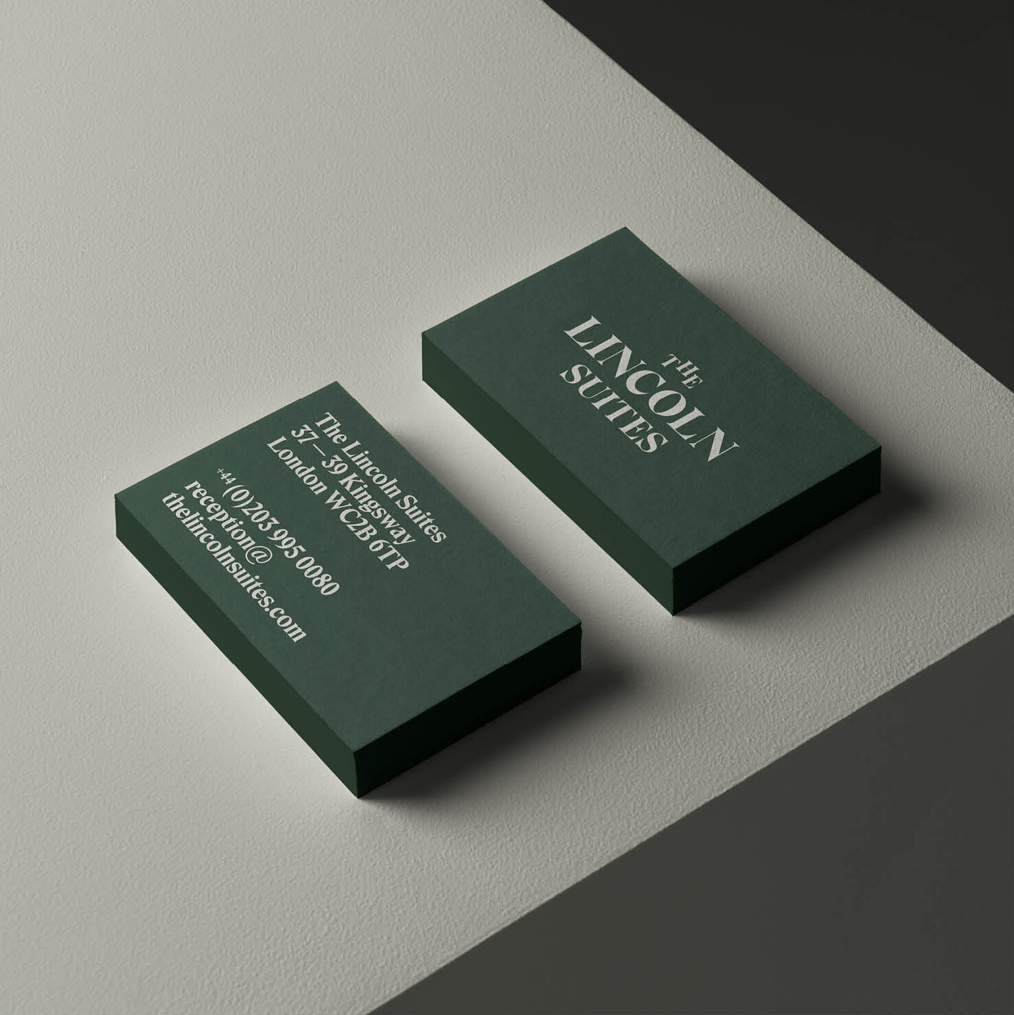 Stack of business cards for Lincoln Suites, featuring contact details and address.
