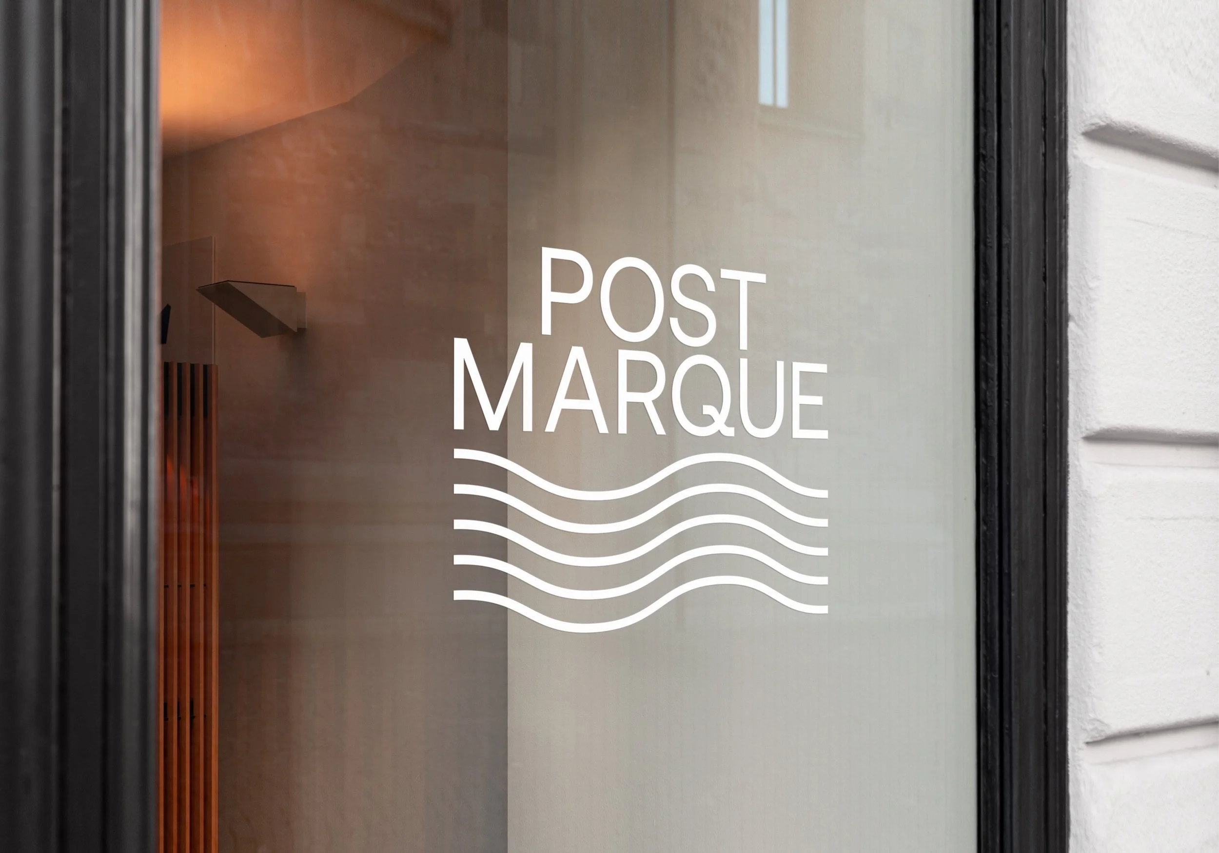 Glass door with the sign 'Post Marque' and wavy lines beneath the text.