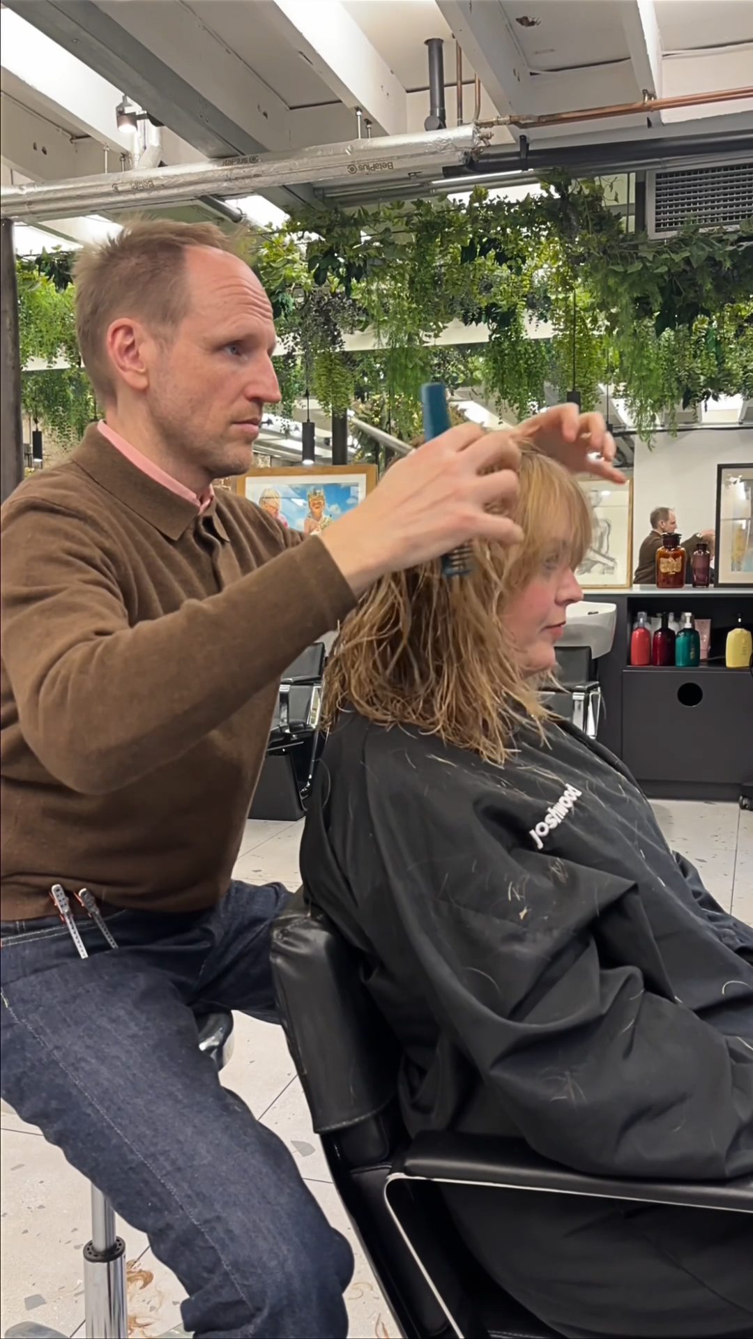 Greg Hill blow-drying hair during an in-salon styling session.