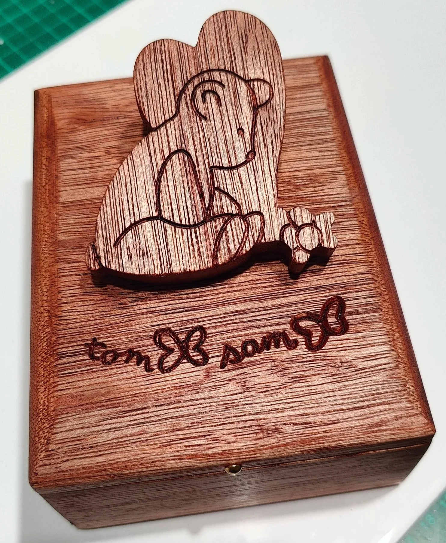 Wooden box with engraved hand drawn line art of a sad teddy bear, love heart and butterfly, with handwritten message on the lid.