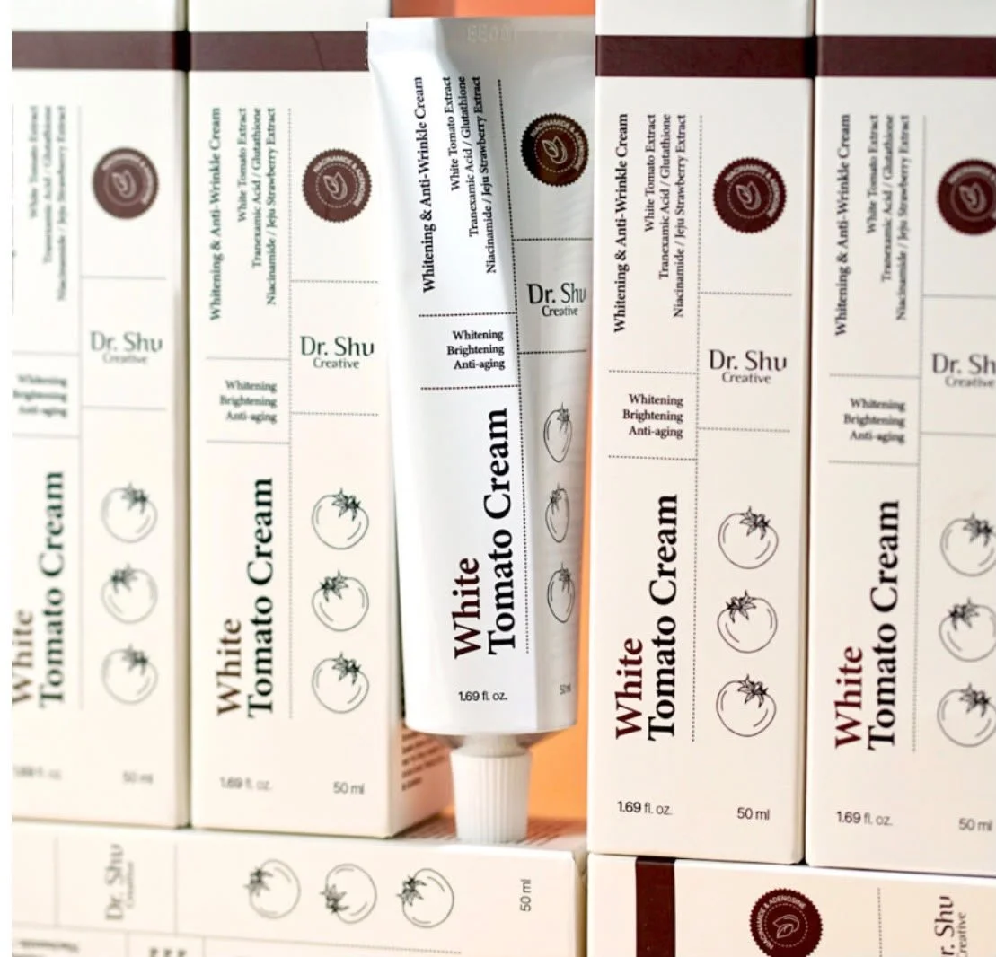 Tube of Dr. Shu Whitening & Anti-Wrinkle White Tomato Cream surrounded by boxes of the same product.