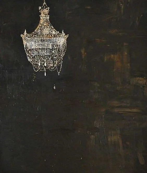 Un candelabro o lámpara de araña de cristal colgada del techo, suspendida en un fondo oscuro.