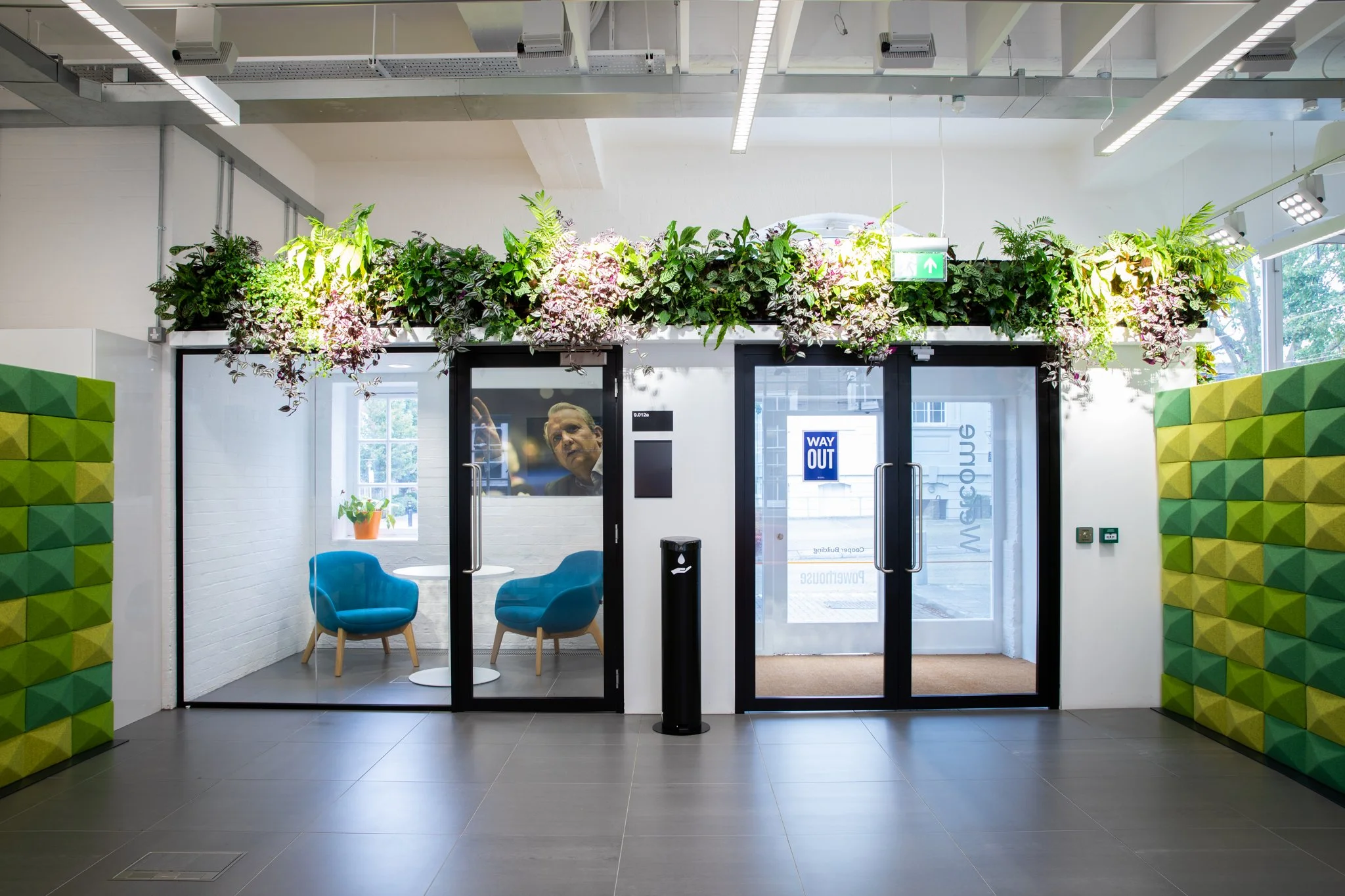 Image shows the foyer of a smart university building with sound-proofed panels and an integrated office with glass partitions