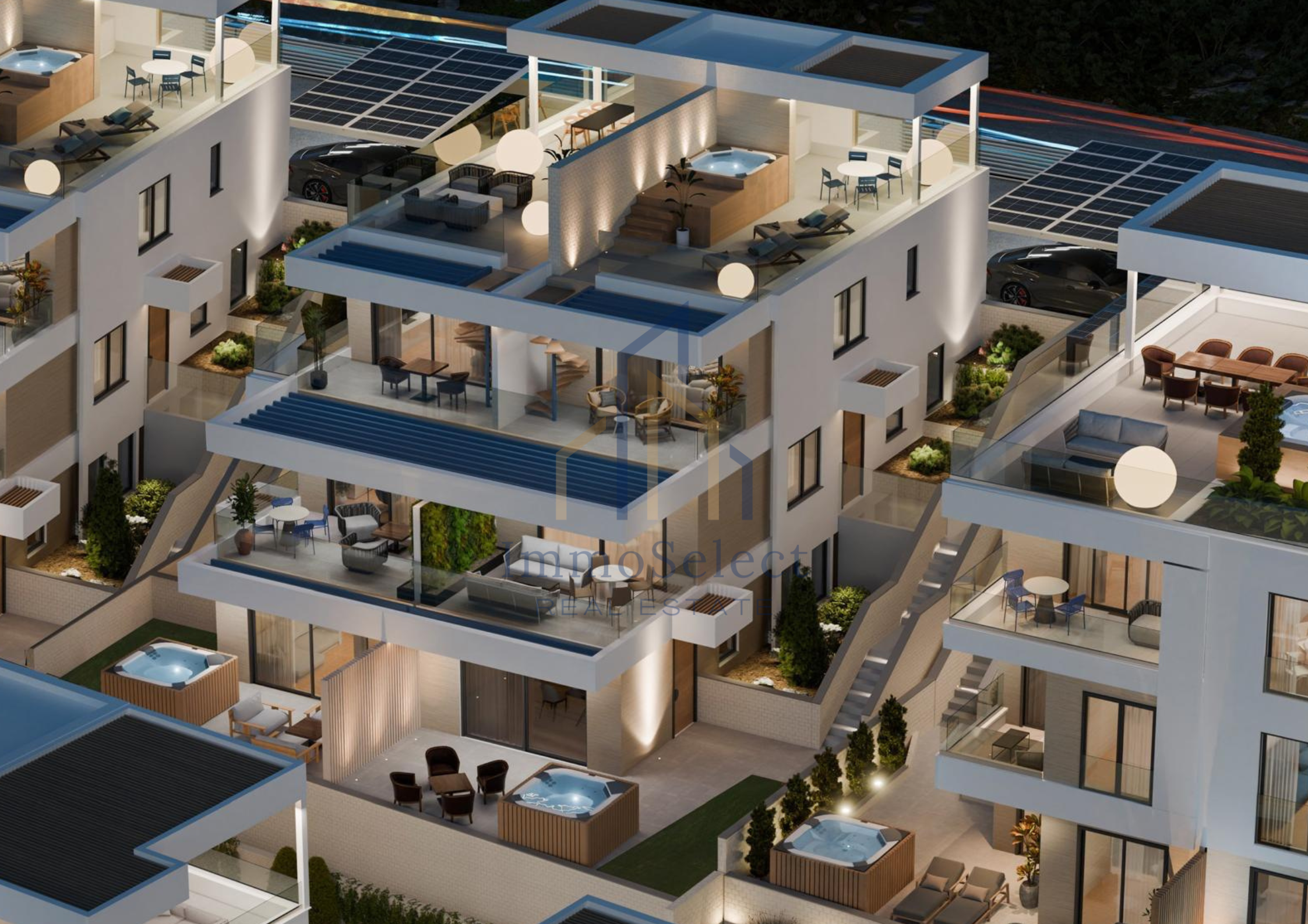 Aerial view of modern multi-story residential buildings with rooftop terraces, outdoor furniture, hot tubs, and solar panels, illuminated during the evening.