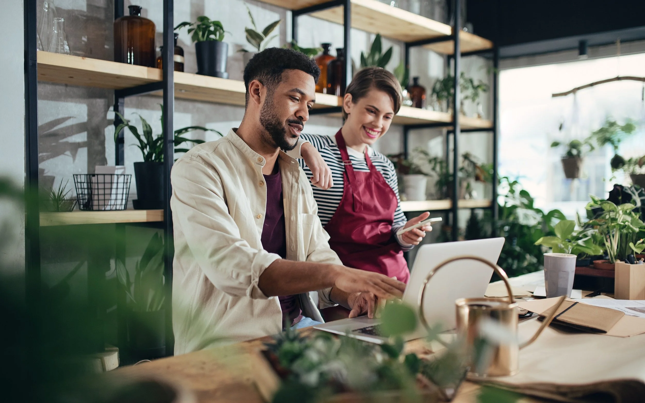 two small business owners in shop looking at computer