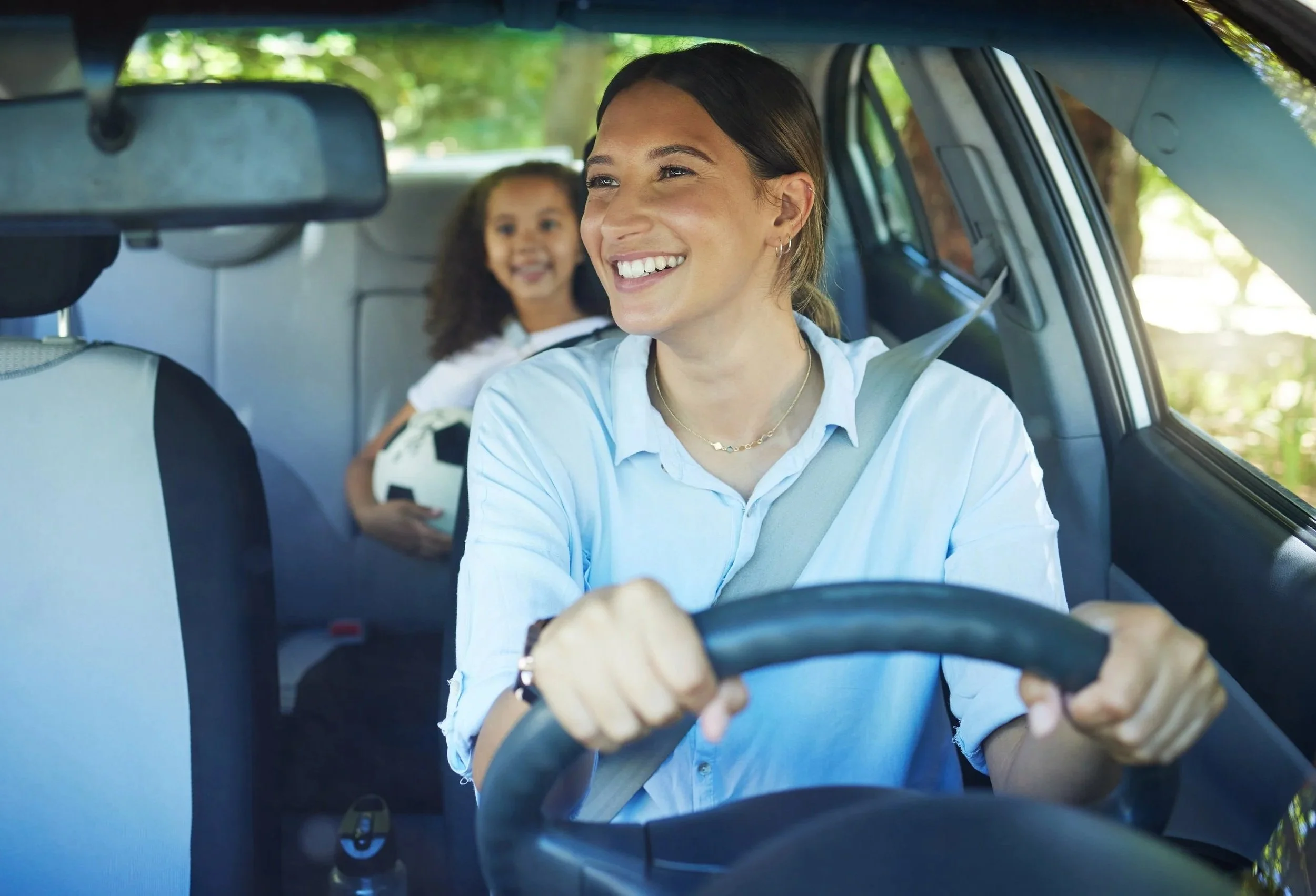 Mom, driver and girl passenger in vehicle, smile and bonding on road