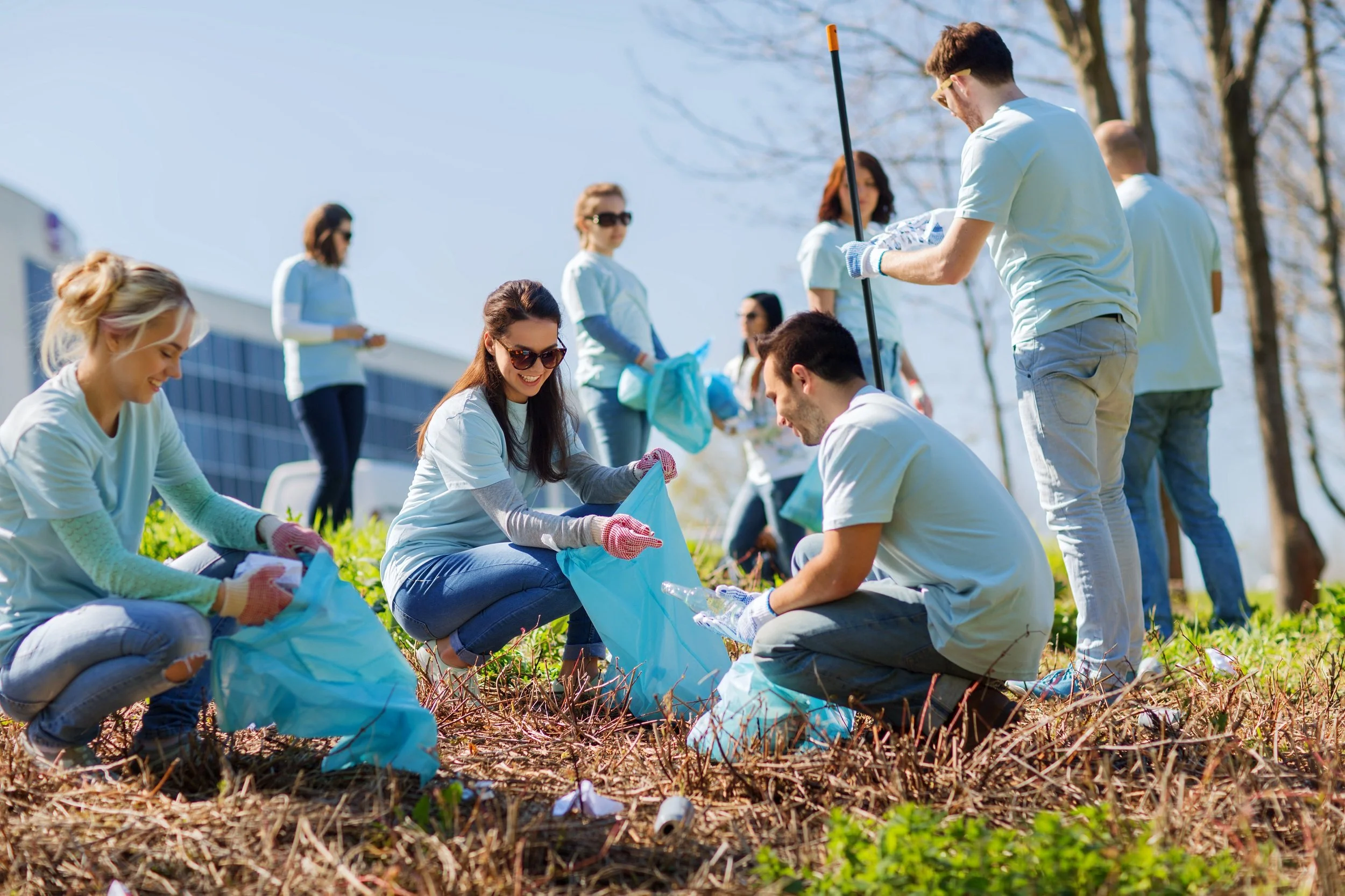 smiling volunteers planting trees outside