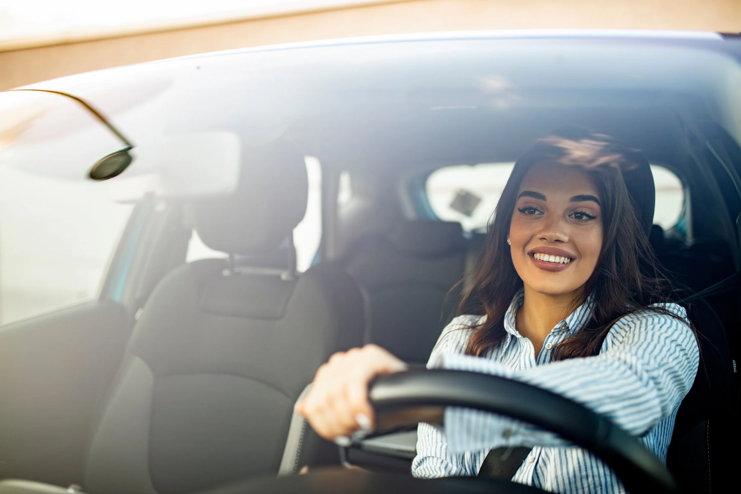 woman smiling while driving her car