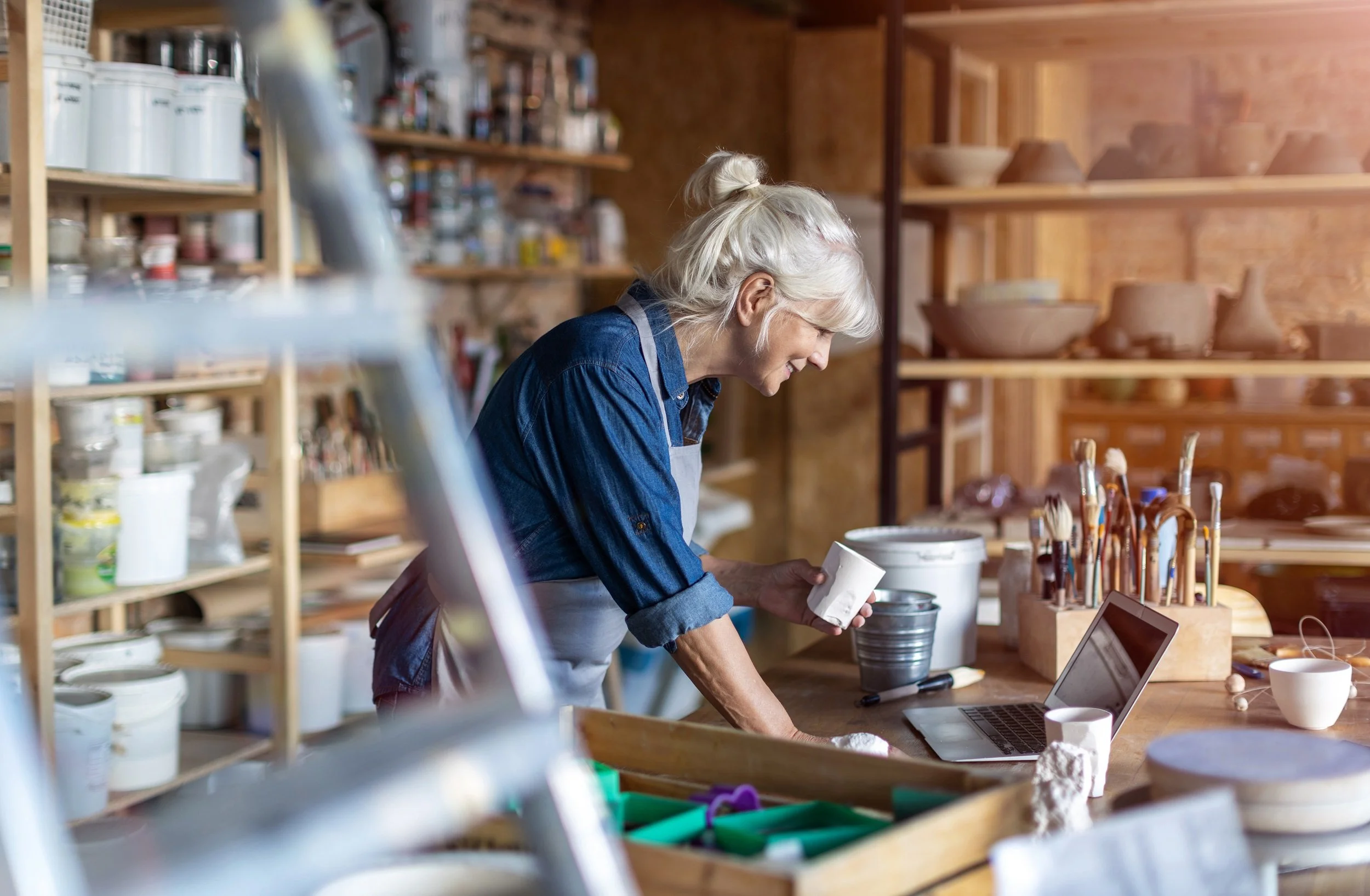 senior female pottery artist in her art studio