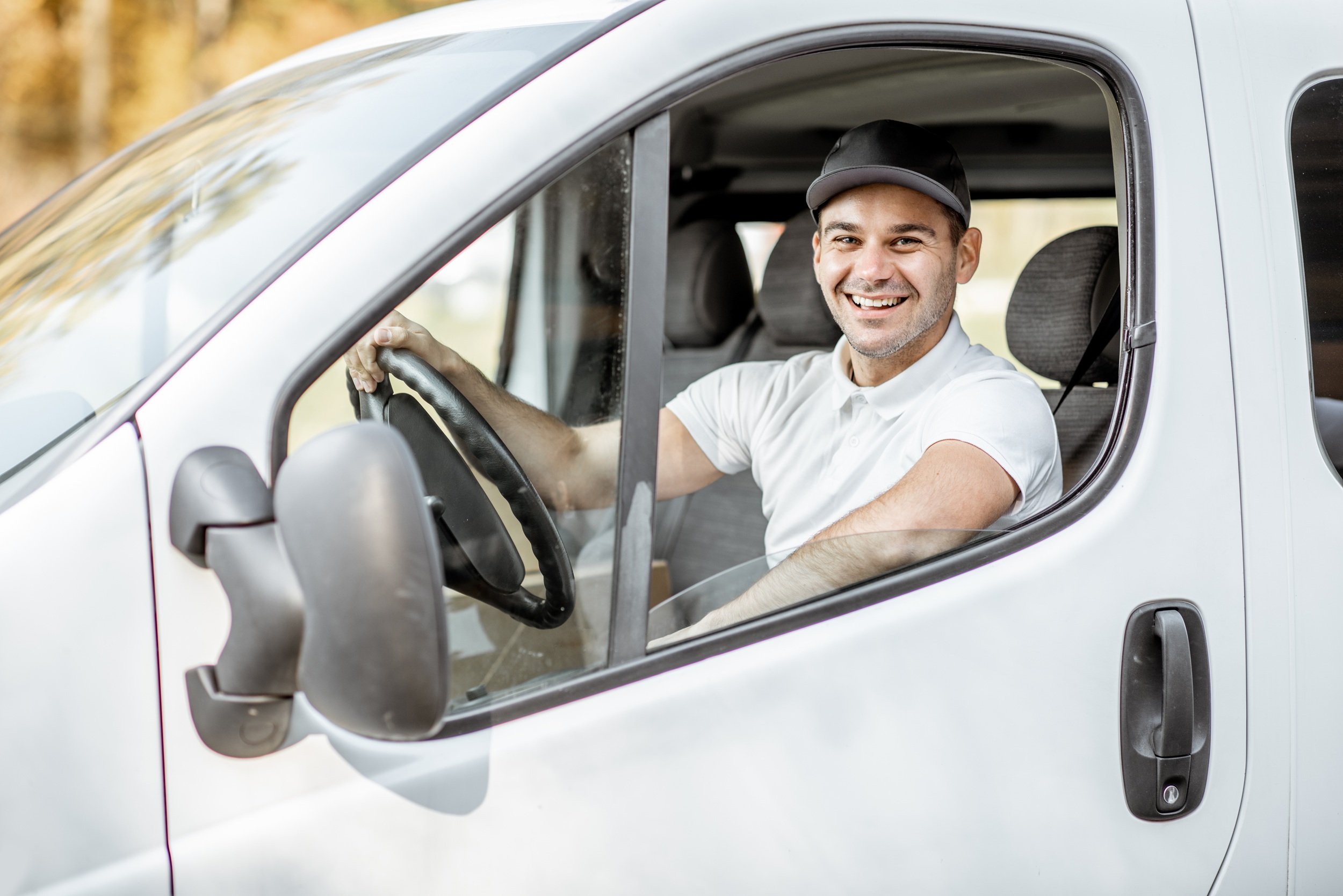male delivery driver smiling in car
