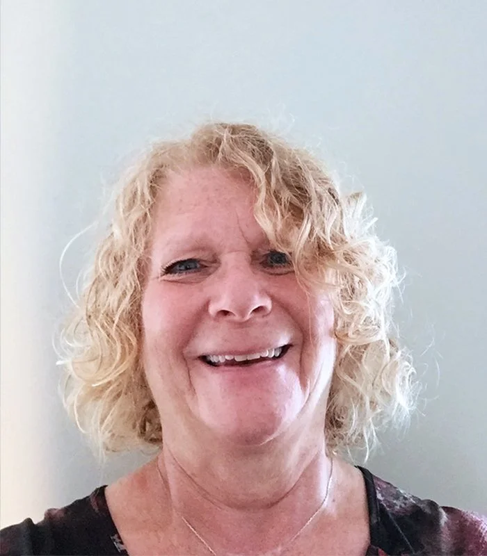 Janice Rapp headshot with curly blonde hair wearing a black top.