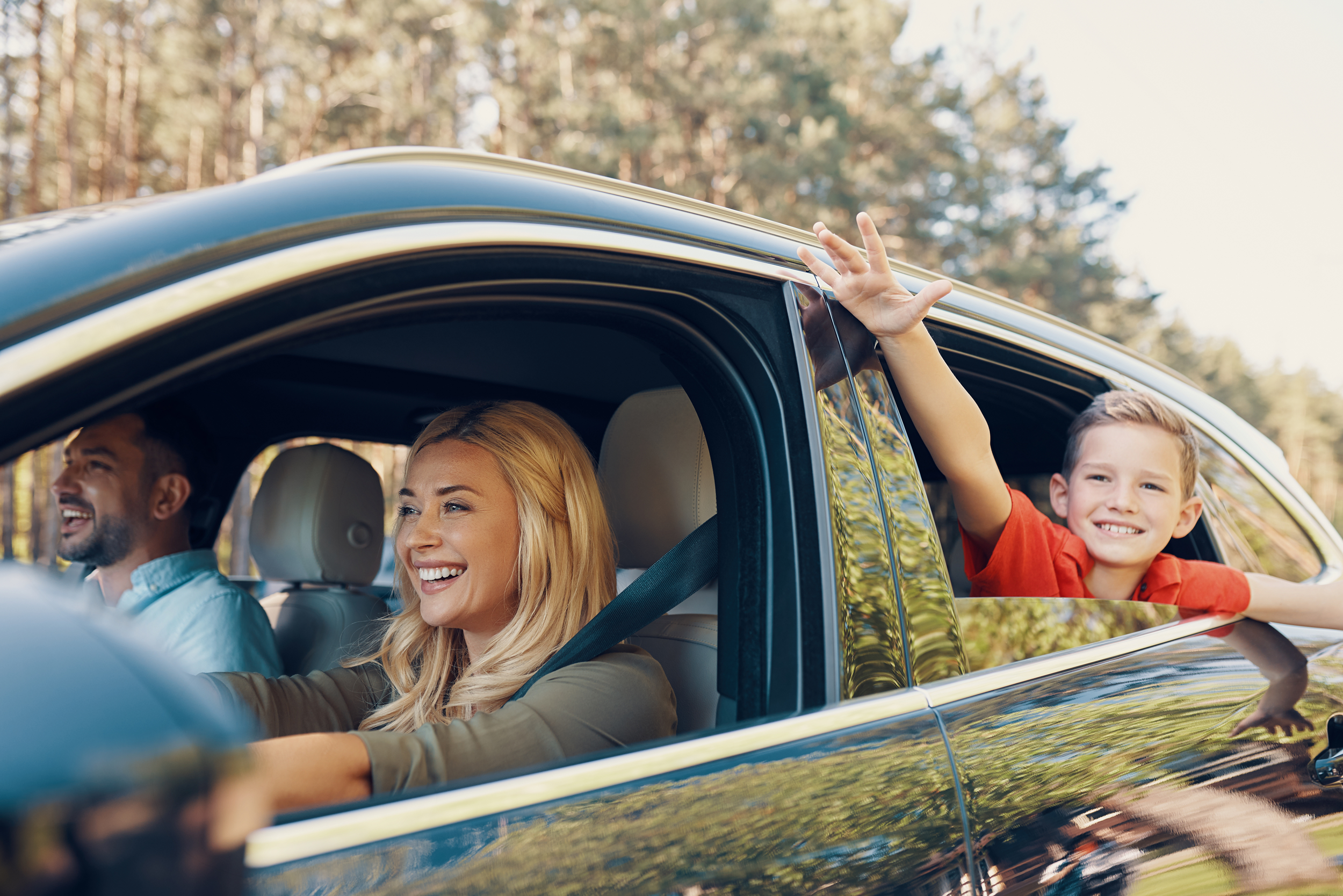 family with little boy driving in the car