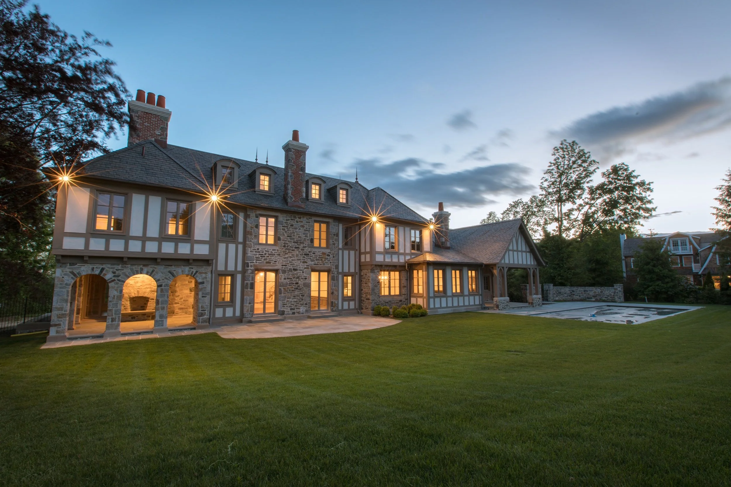high net worth home in the evening with the lights on