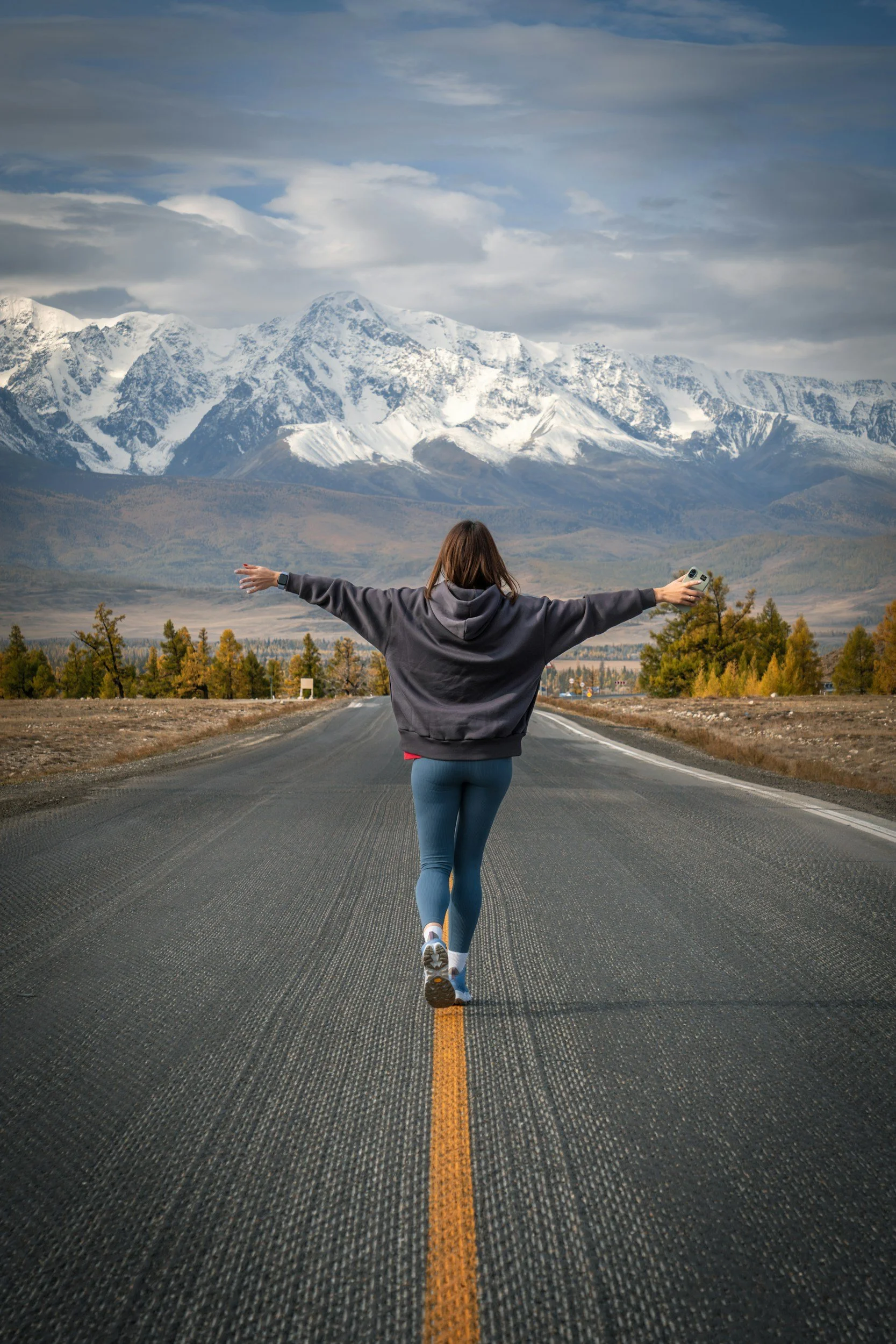 a person walking in the street towards mountains that are covered in snow