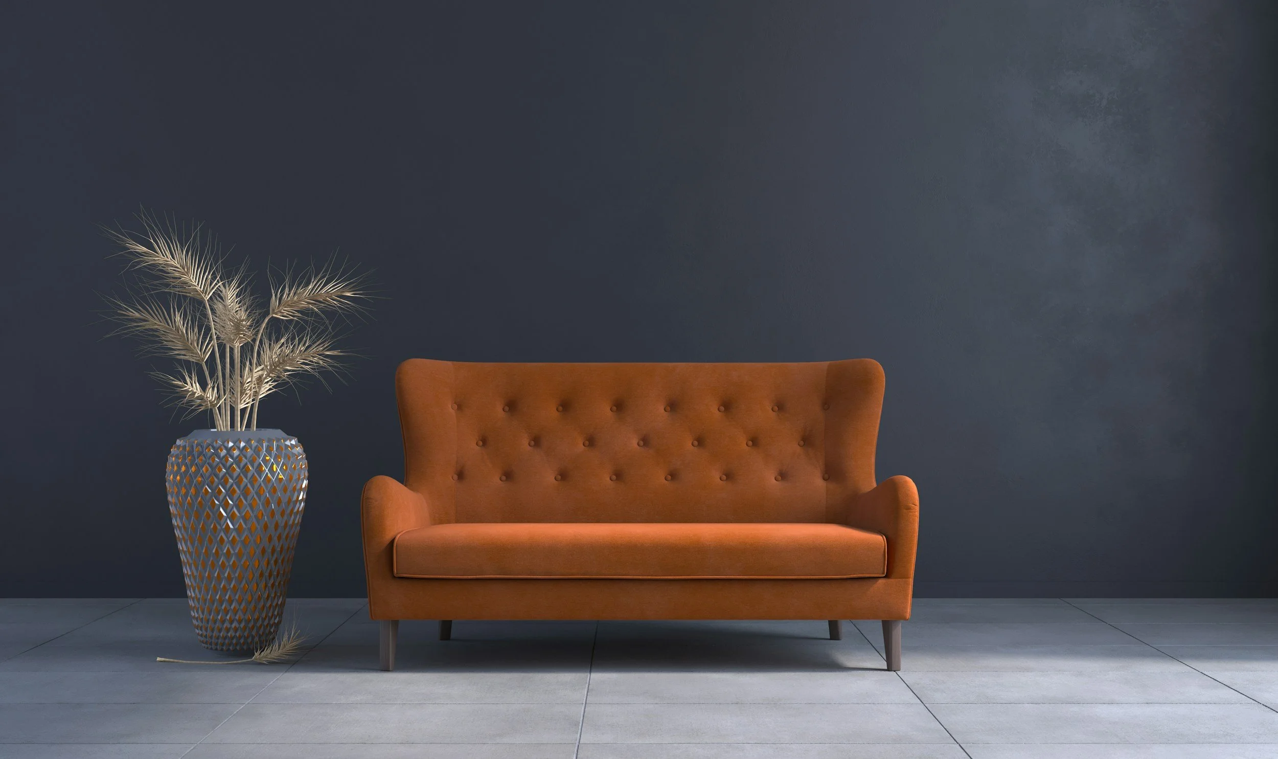 Tan couch in a blue and grey room with a grey plant next to it.