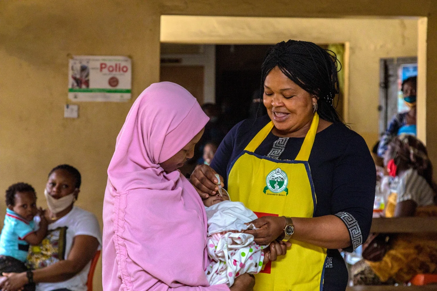 Rotarian and Lagos State immunization officer Bola Orefejo (right) vaccinates a child against polio at Ikosi Health Center in Lagos, Nigeria. 28 July 2020