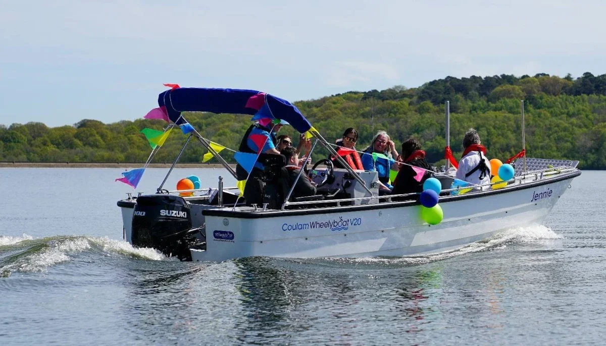 Wheelyboat Jennie on her maiden voyage at Bewl Water being helmed by a wheelchair user.