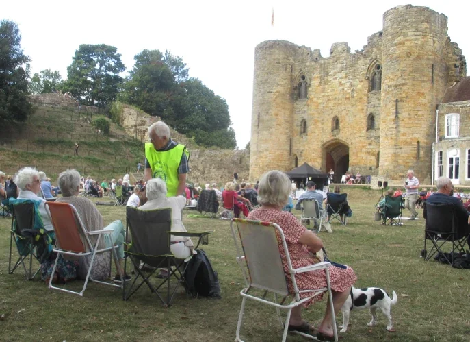 A Rotarian chatting to people at an open air concert on Tonbridge Castle lawn