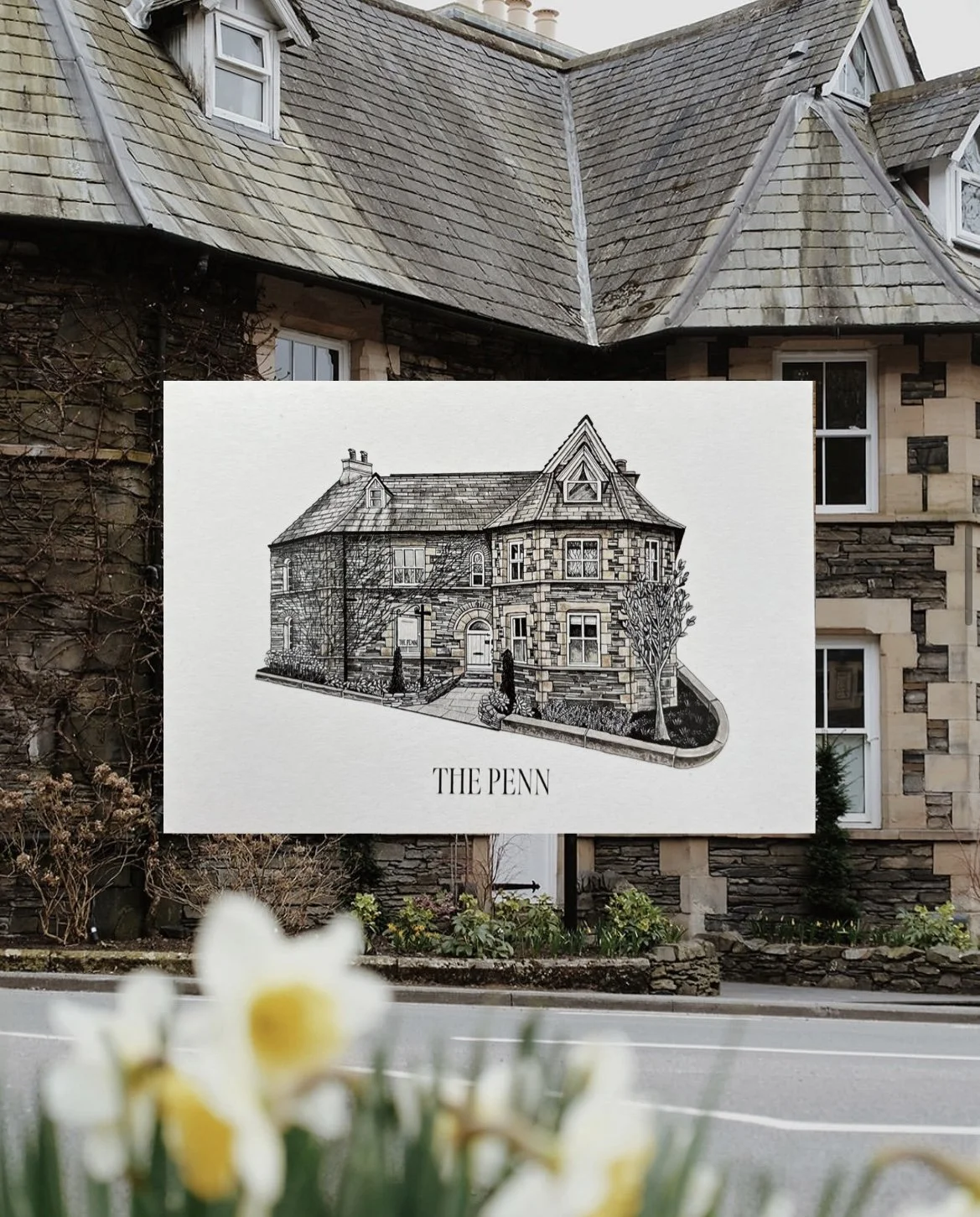 A black-and-white illustration of a house labeled 'The Penn' in front of a real house with stone walls and a shingled roof.