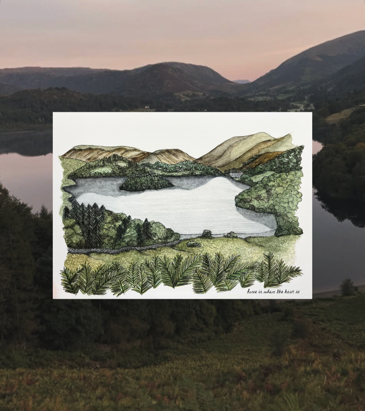 A drawing of a landscape featuring a lake surrounded by green trees, hills, and mountains under a pinkish sky, with a handwritten note saying 'home is where the heart is'.