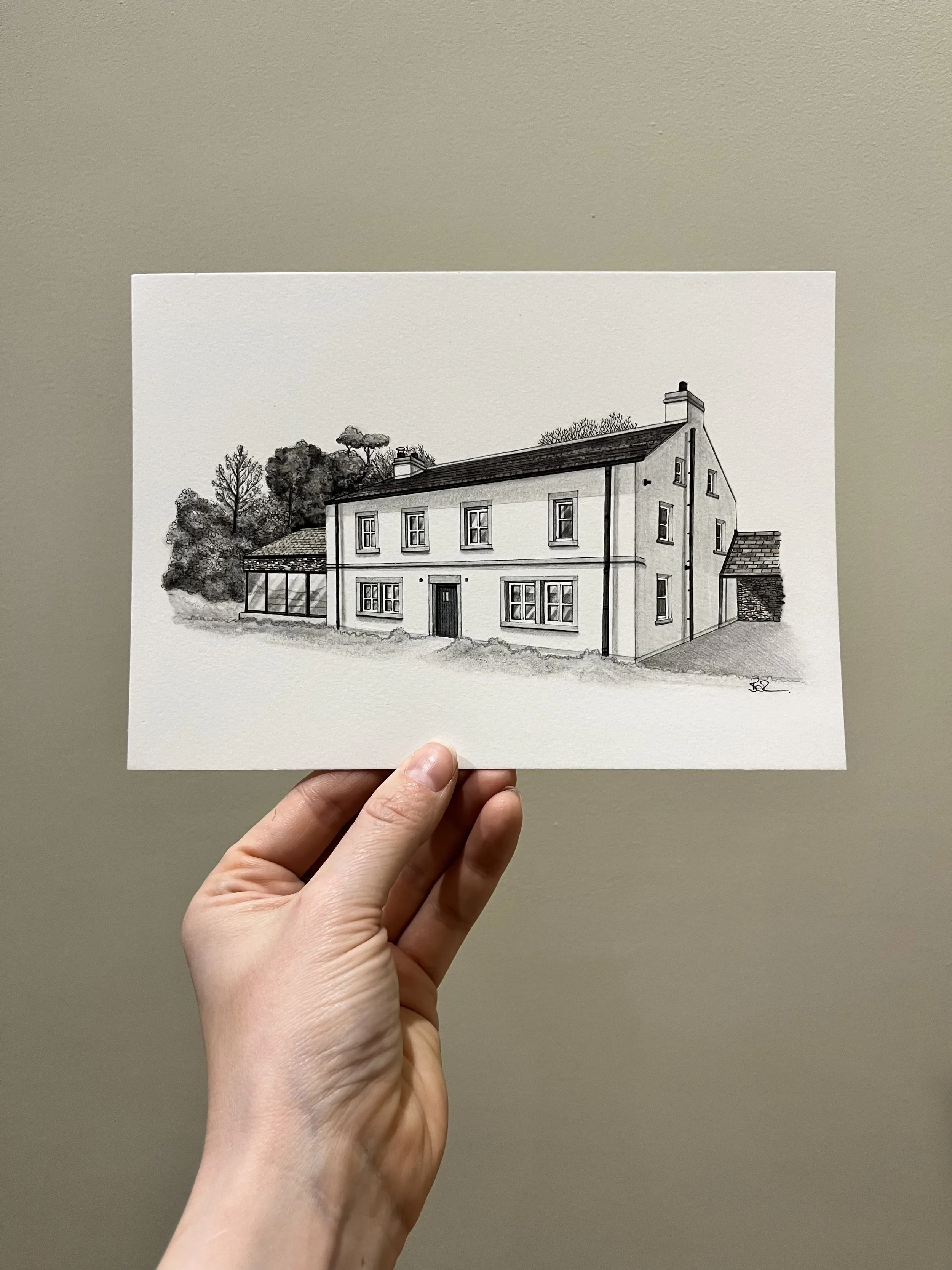 Black and white sketch of a house with multiple windows, a door, and a chimney on a plain background.