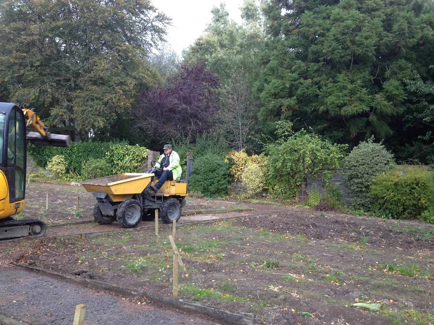 A groundworker using a dumper to fill new beds with topsoil and compost in the Marian Garden at Kilcoy Castle.