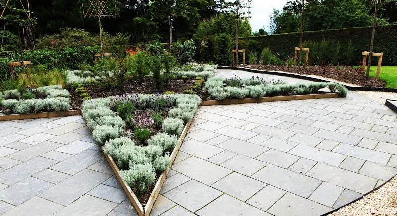 The star beds in the centre of the Marian Garden at Kilcoy Castle, planted with santolina hedging and surrounded by stone slab paving and fine gravel paths.