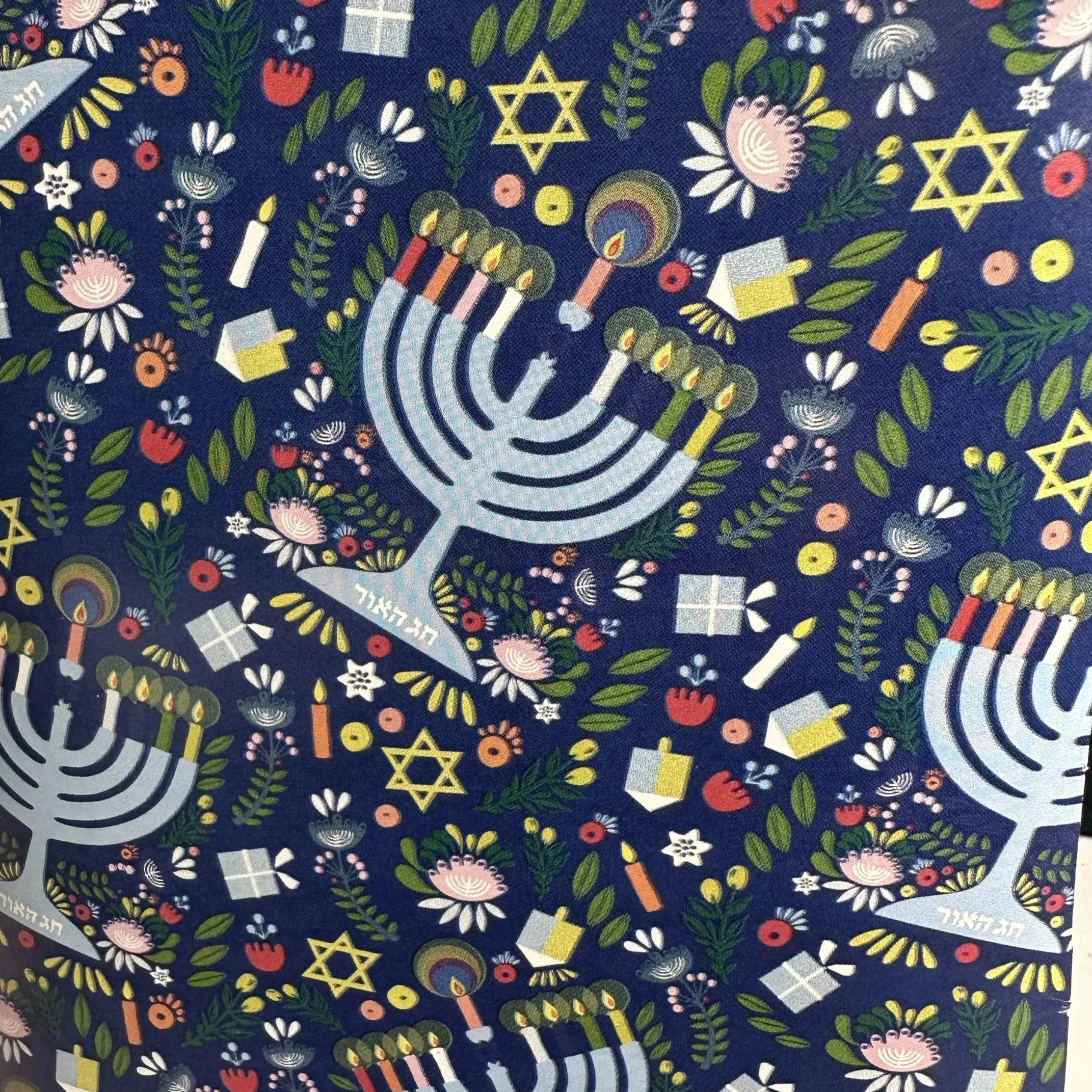 Pattern with menorahs, Hanukkah candles, dreidels, stars of David, gifts, flowers, and leaves on a dark background.