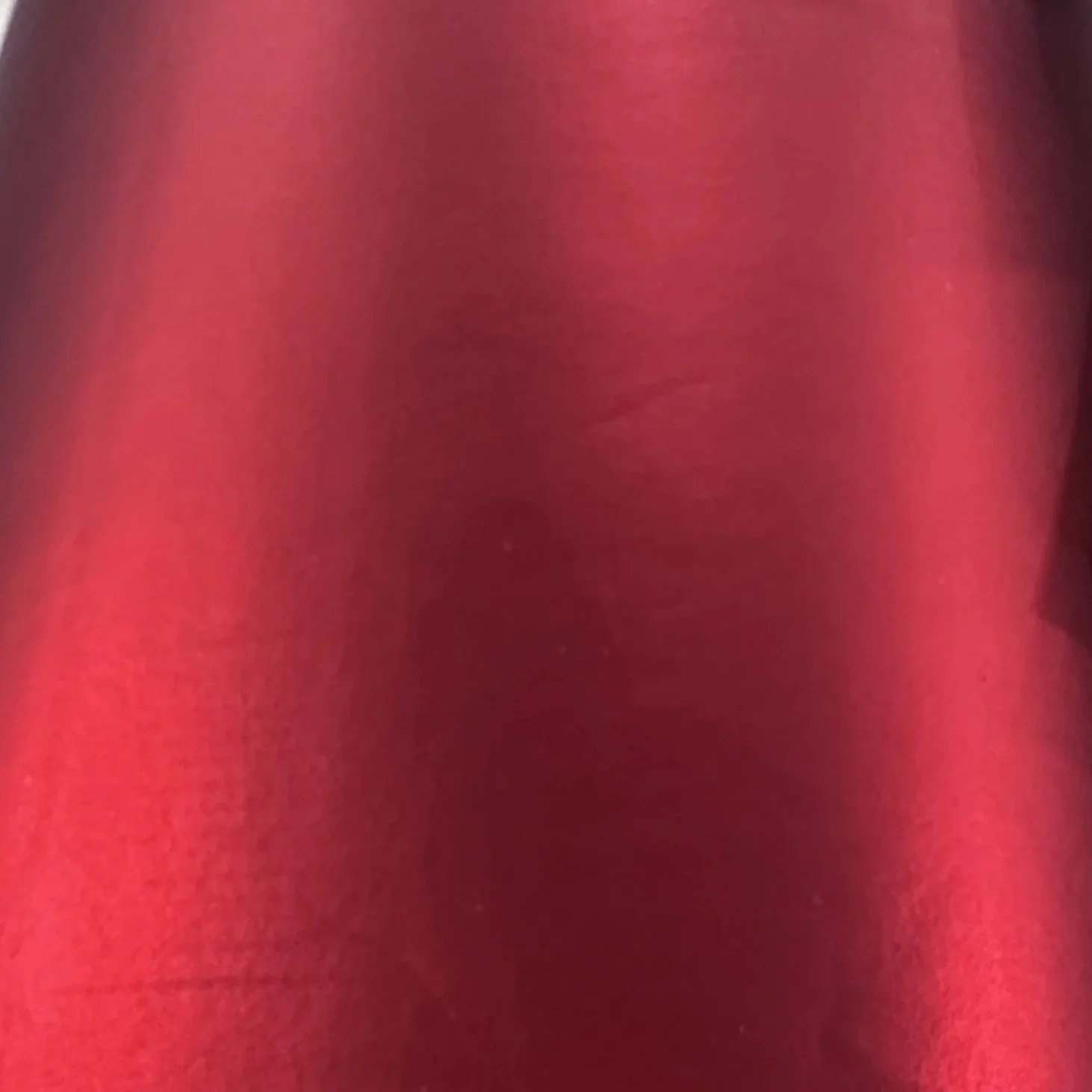 Close-up of pink fabric with smooth texture and slight folds.