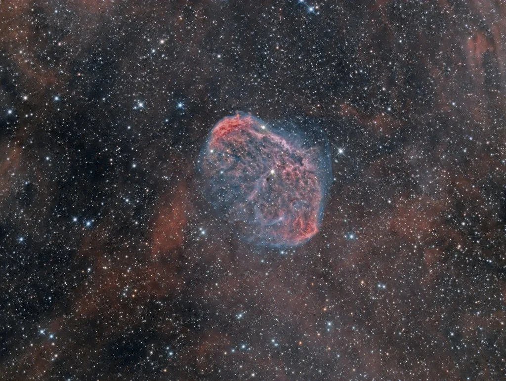 A detailed image of space featuring a colorful nebula surrounded by numerous stars.