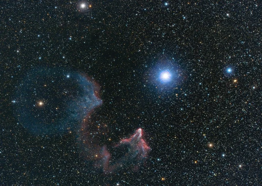 Star-filled sky with a bright star or planet and colorful nebulae in deep space.