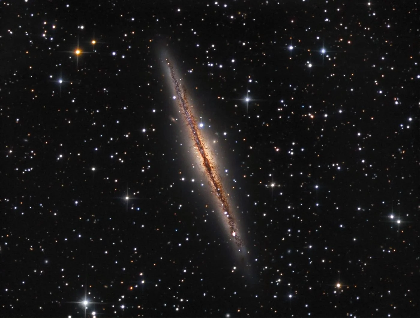 A distant galaxy viewed from space surrounded by stars.