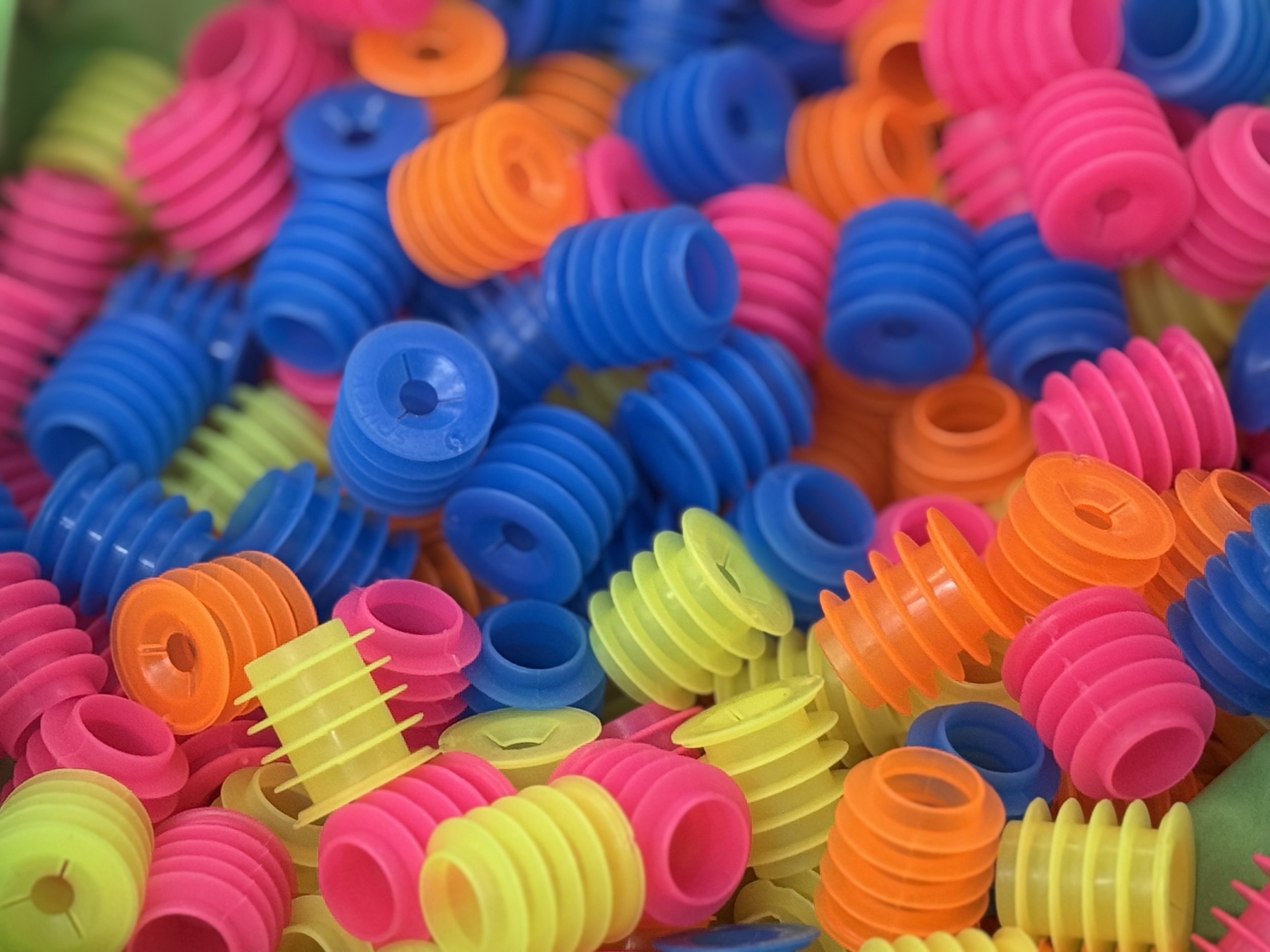 Close-up of colorful plastic spiral hair curlers in pink, blue, yellow, and orange.