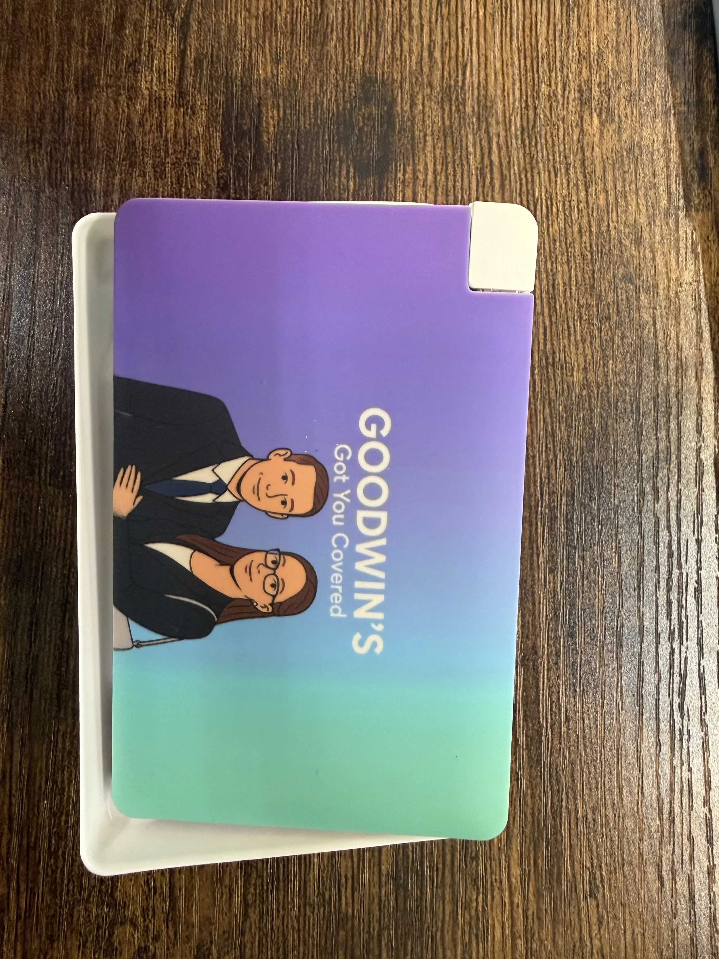 A dramatized card with the text 'Goodwin's Got You Covered' and cartoon figures of a man and a woman in business attire.