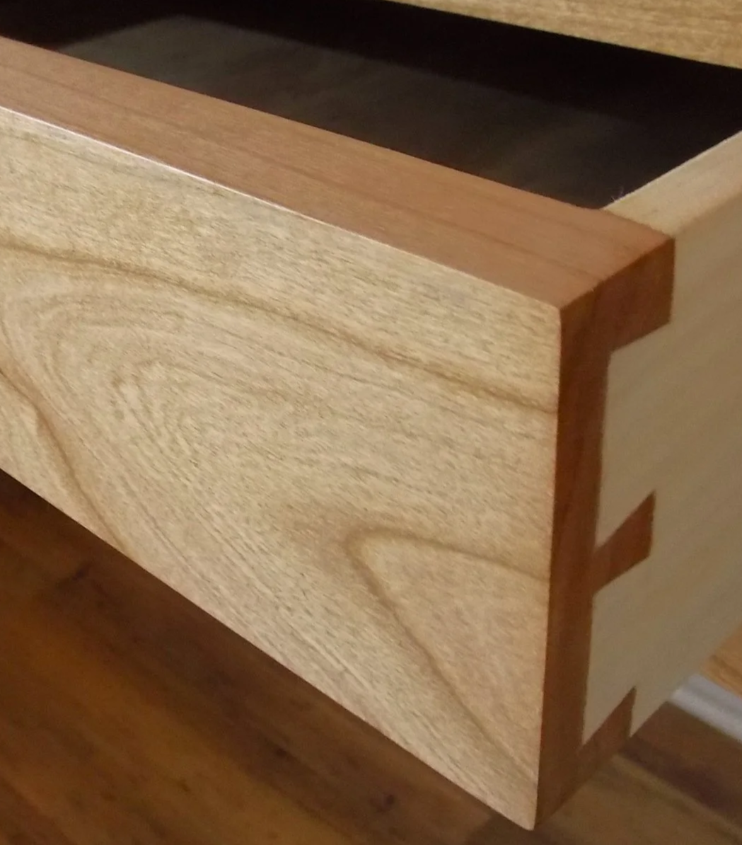 Close-up of a wooden furniture piece with dovetail joints.