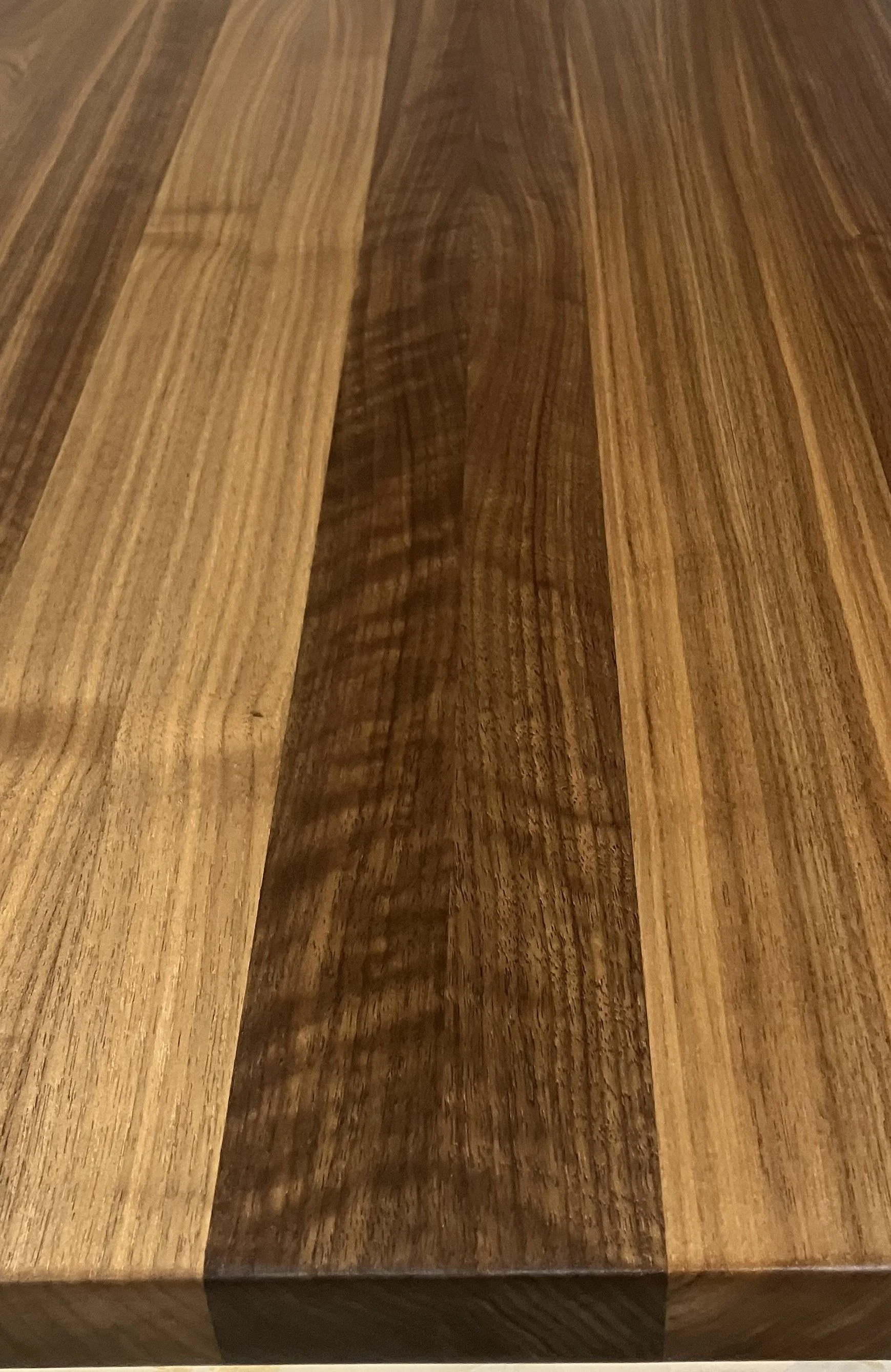 Close-up view of a wooden surface with light and dark wood grain patterns.