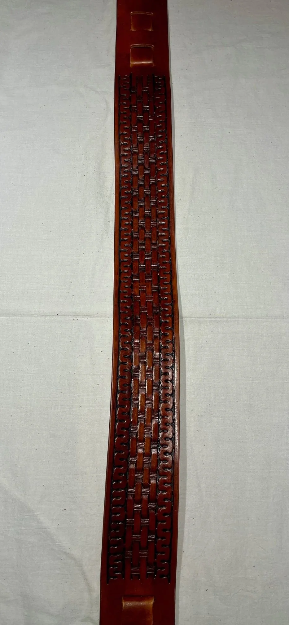 A long wooden decorative lattice strip, possibly a side panel or part of furniture, with intricate cut-out geometric patterns.
