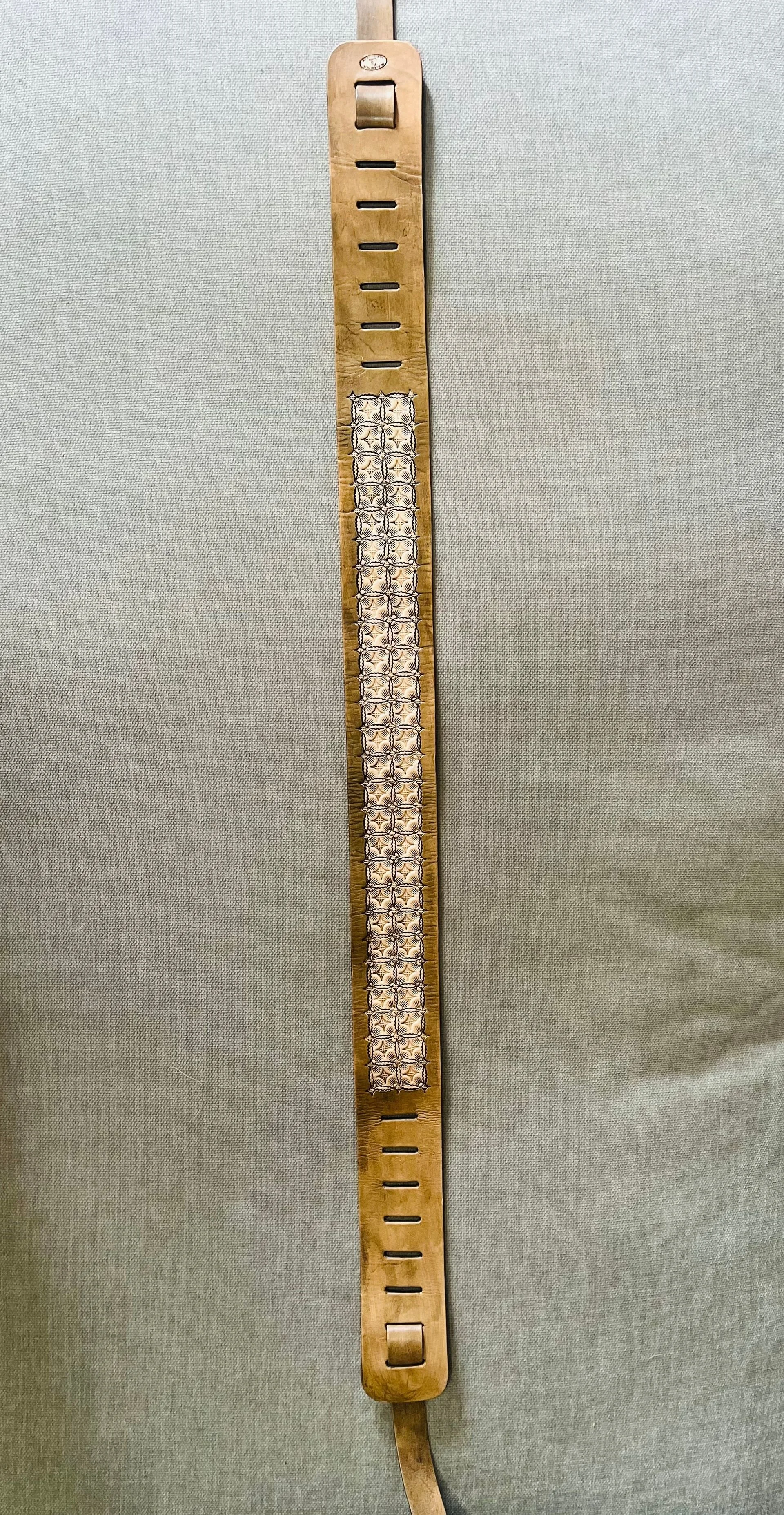 A wooden board with metallic and plastic components, resembling a medical or scientific device, mounted on a light gray surface.