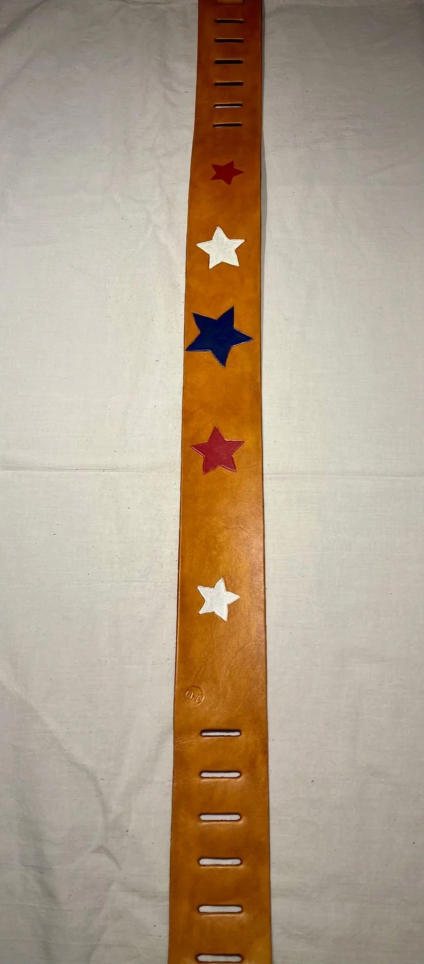 A wooden growth chart with red, white, and blue star decorations on an off-white surface.