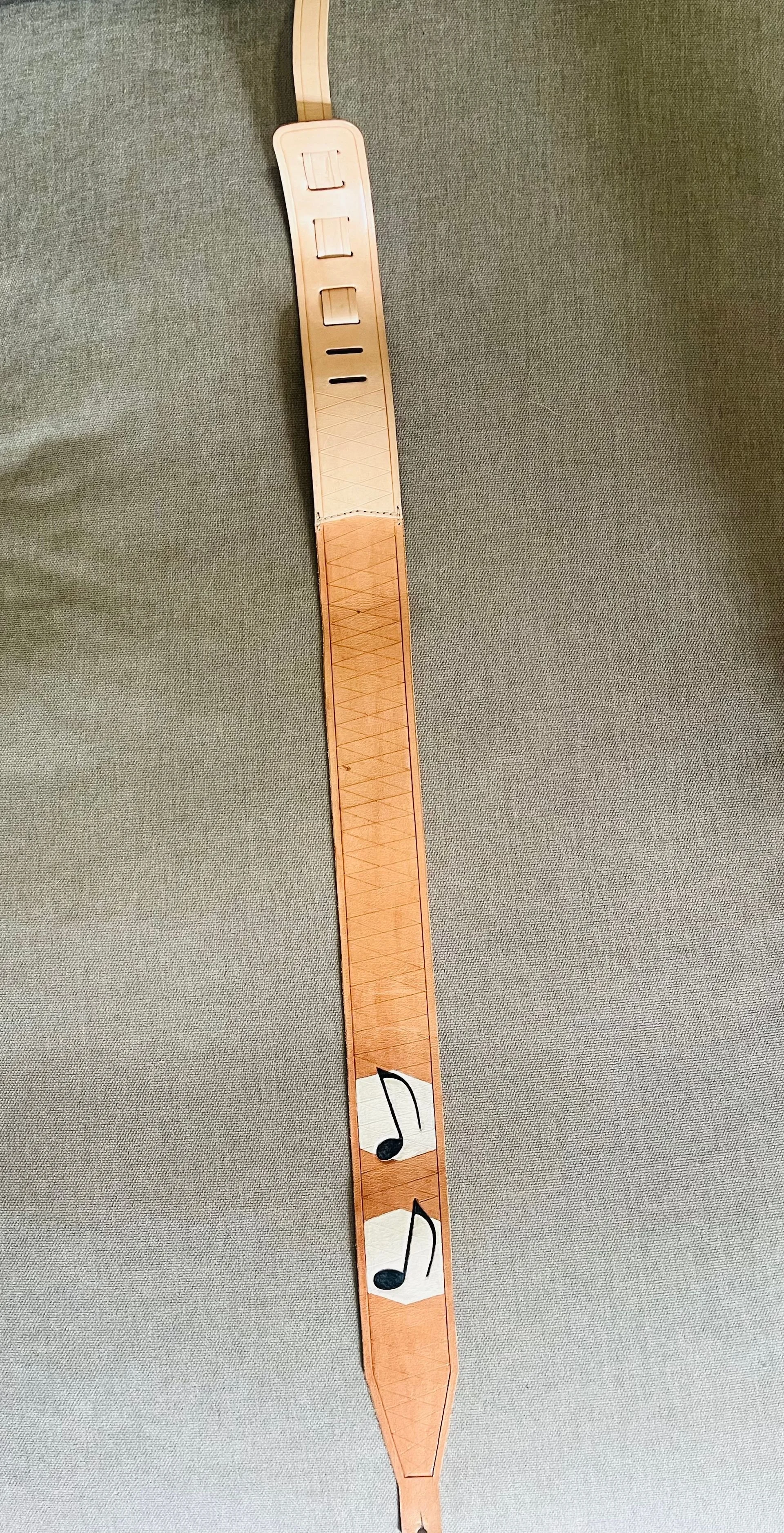 A wooden music staff with two music notes attached to it, positioned vertically on a textured gray background.