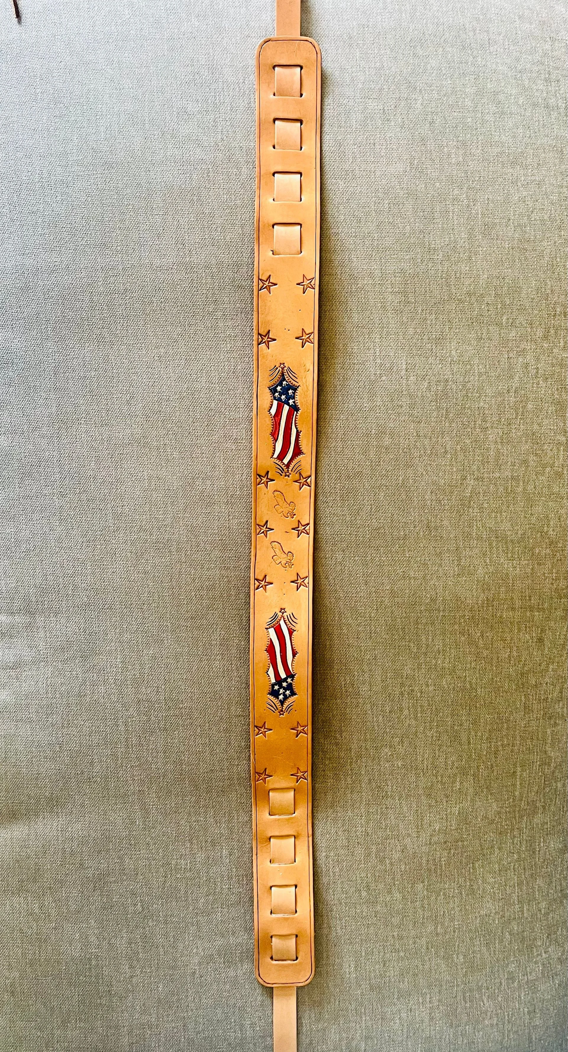 A leather strap with patriotic American flag-themed decorations, stars, and eagle emblems.