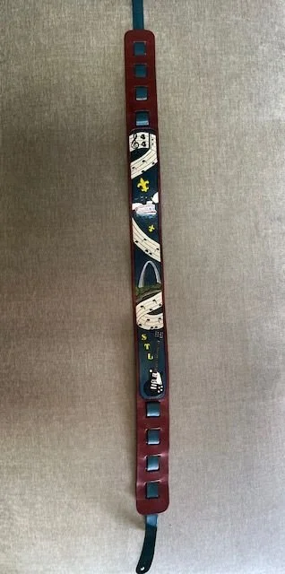 A long, narrow, red and blue electronic game controller with a colorful space-themed design featuring a spaceship, stars, and planets, connected to a cable at the top.