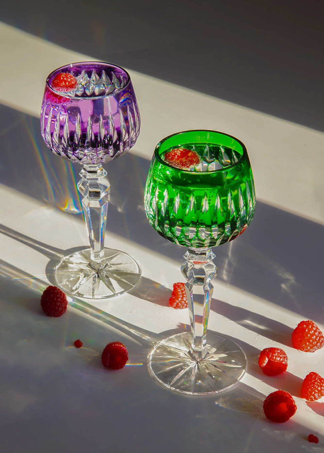 two colourful wine glasses in evening light with raspberries catherinelewisphotography.jpg