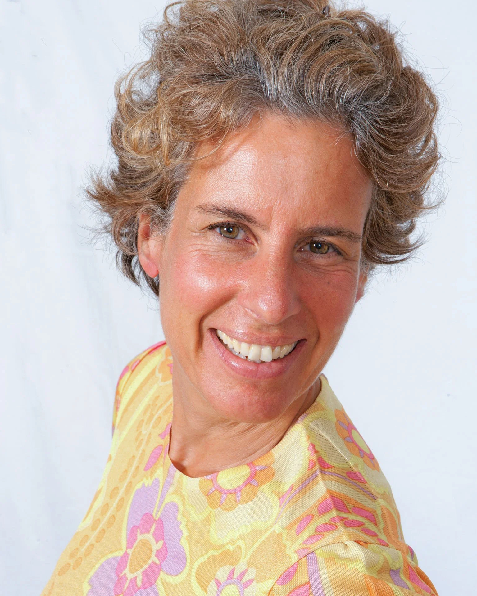 portrait of a lady smiling in a yellow top.jpg