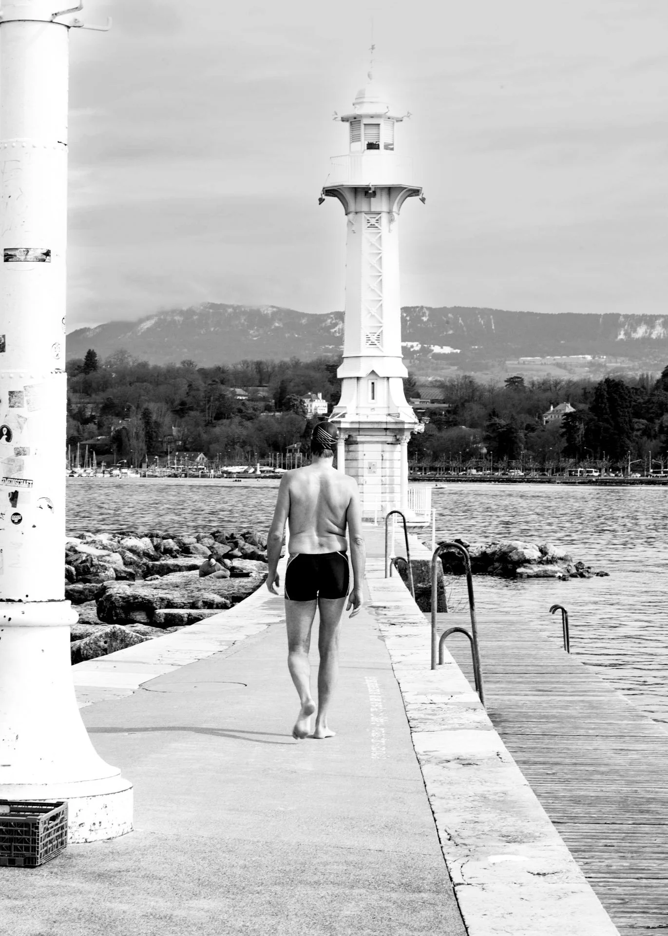 man walking towards a lighthouse in swimmers in geneva catherinelewisphotography.jpg