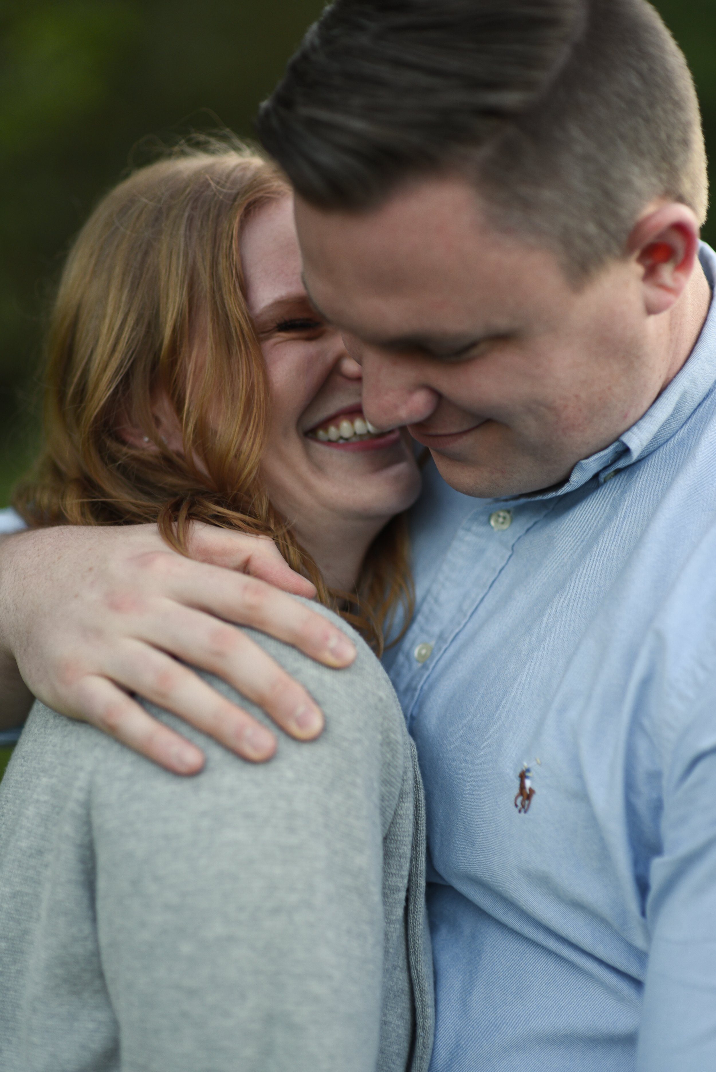 A couple embracing outdoors, smiling and showing affection.